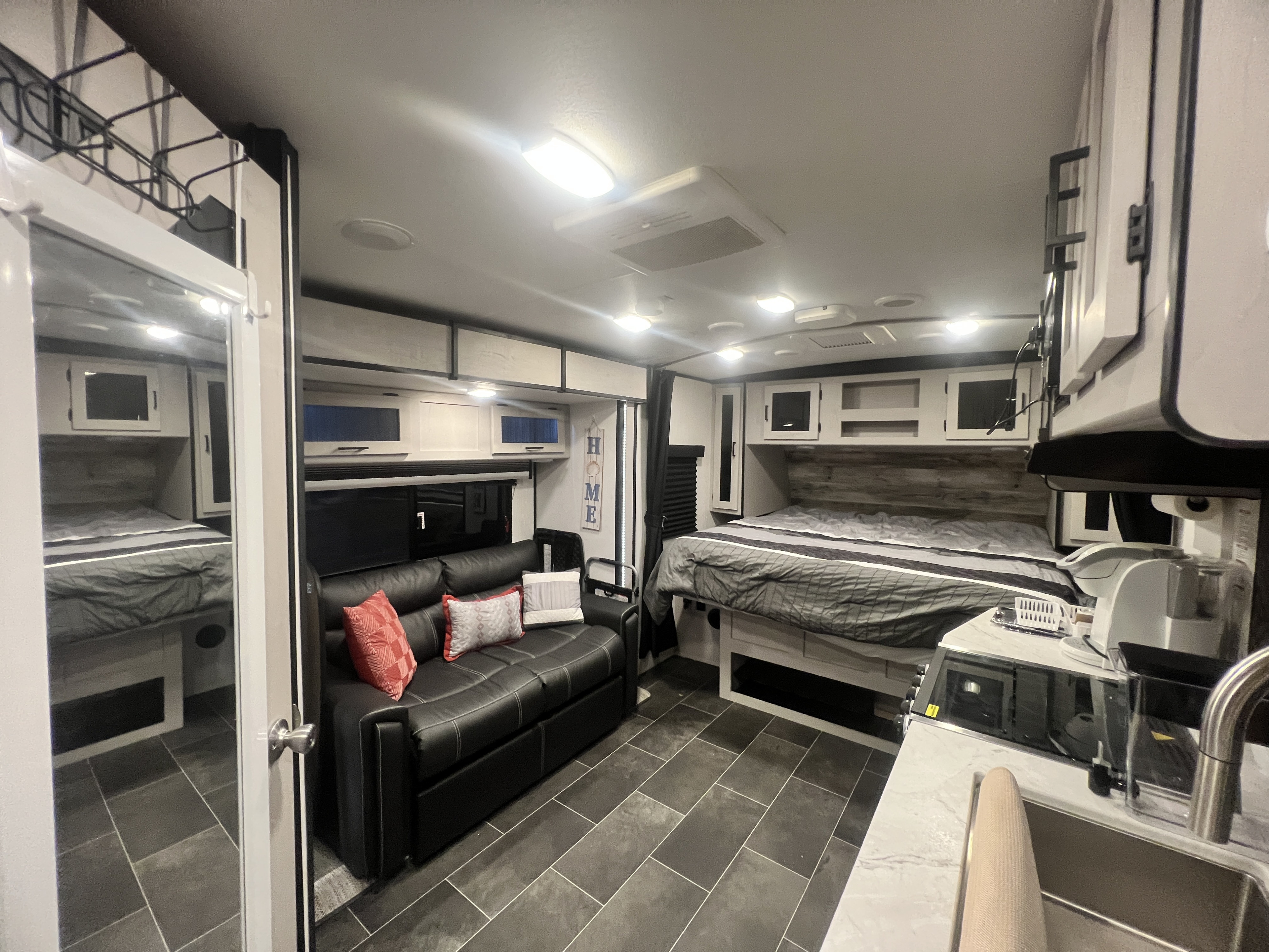 Explore this modern RV rental interior featuring a comfortable bed, stylish sofa, and compact kitchen—your home on the road.. Heartland RVs Mallard 2022