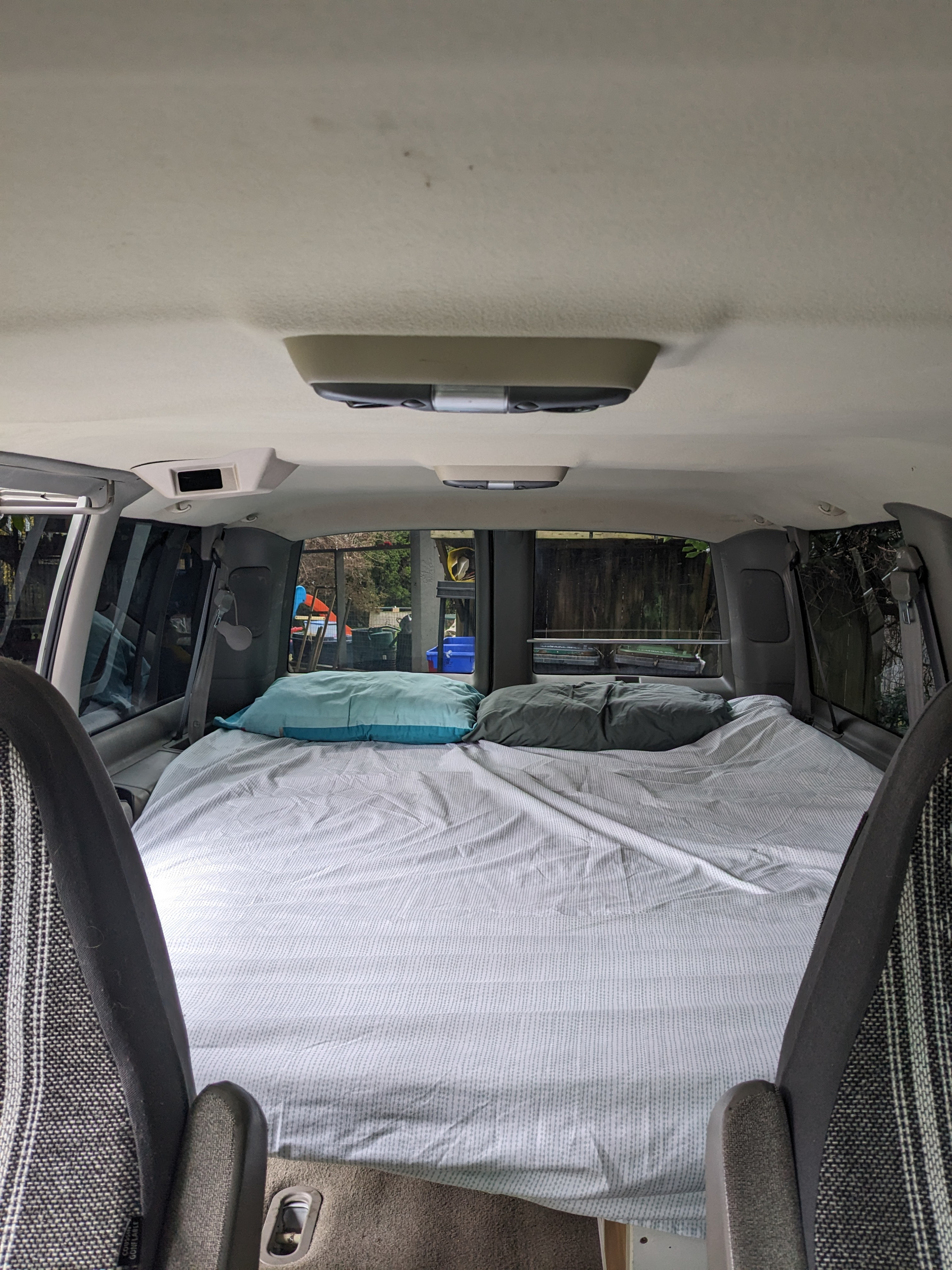 Cozy RV rental interior featuring a comfortable bed with pillows in the rear, ready for camping or road trips.. Chevrolet Open Road 2002