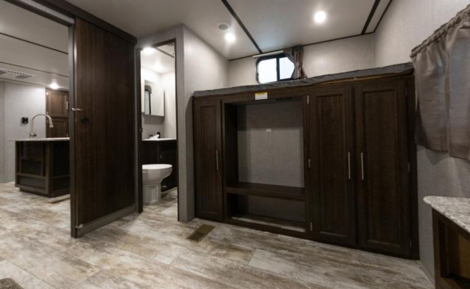 RV rental interior showcasing a compact kitchen, bathroom, and bunk bed with built-in storage.. Crossroads RV Zinger 2018