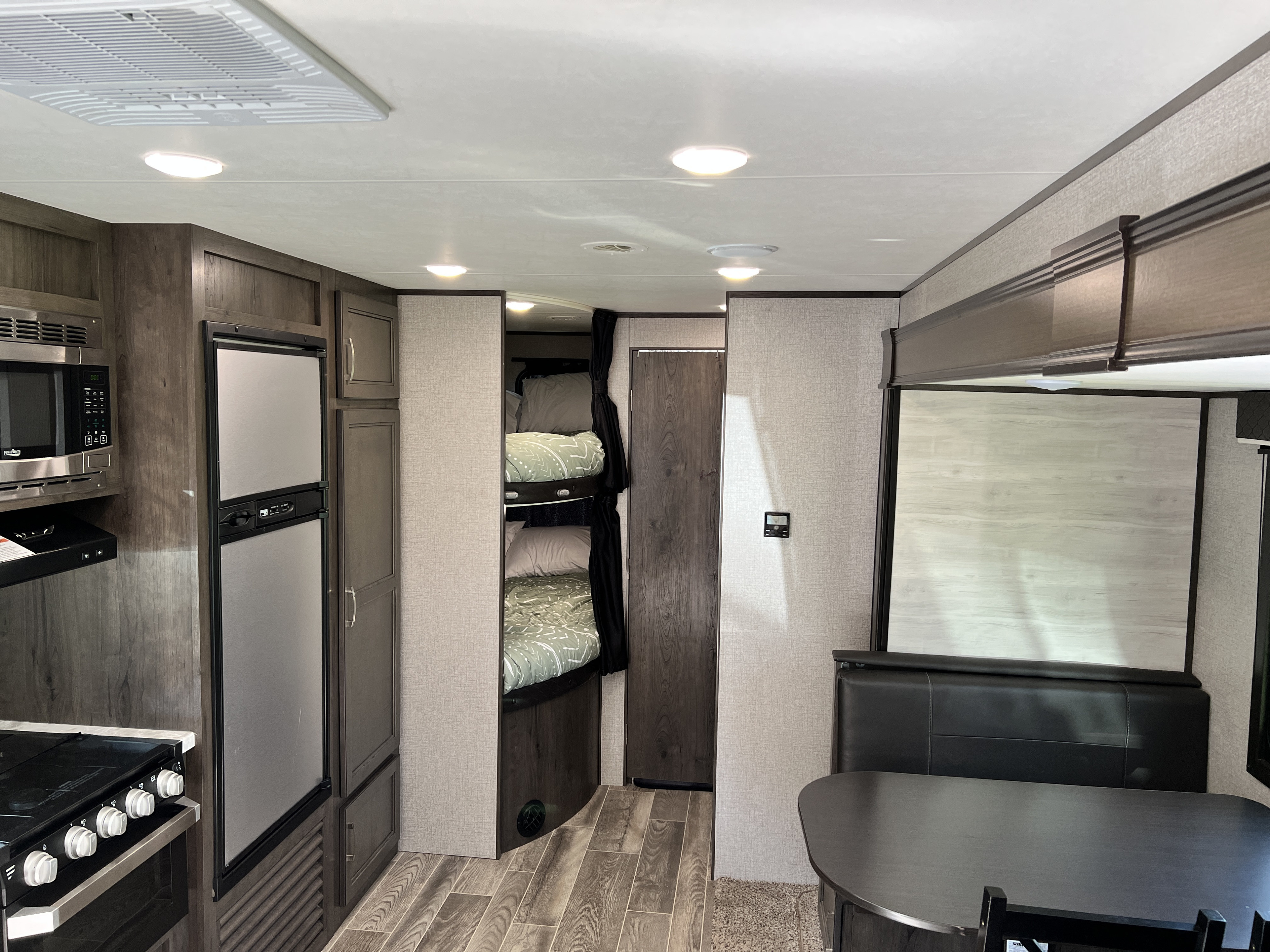 Spacious and modern RV rental interior featuring a full kitchen, comfortable bunk beds, and a cozy dinette area.. Jayco Jay Flight SLX 2021