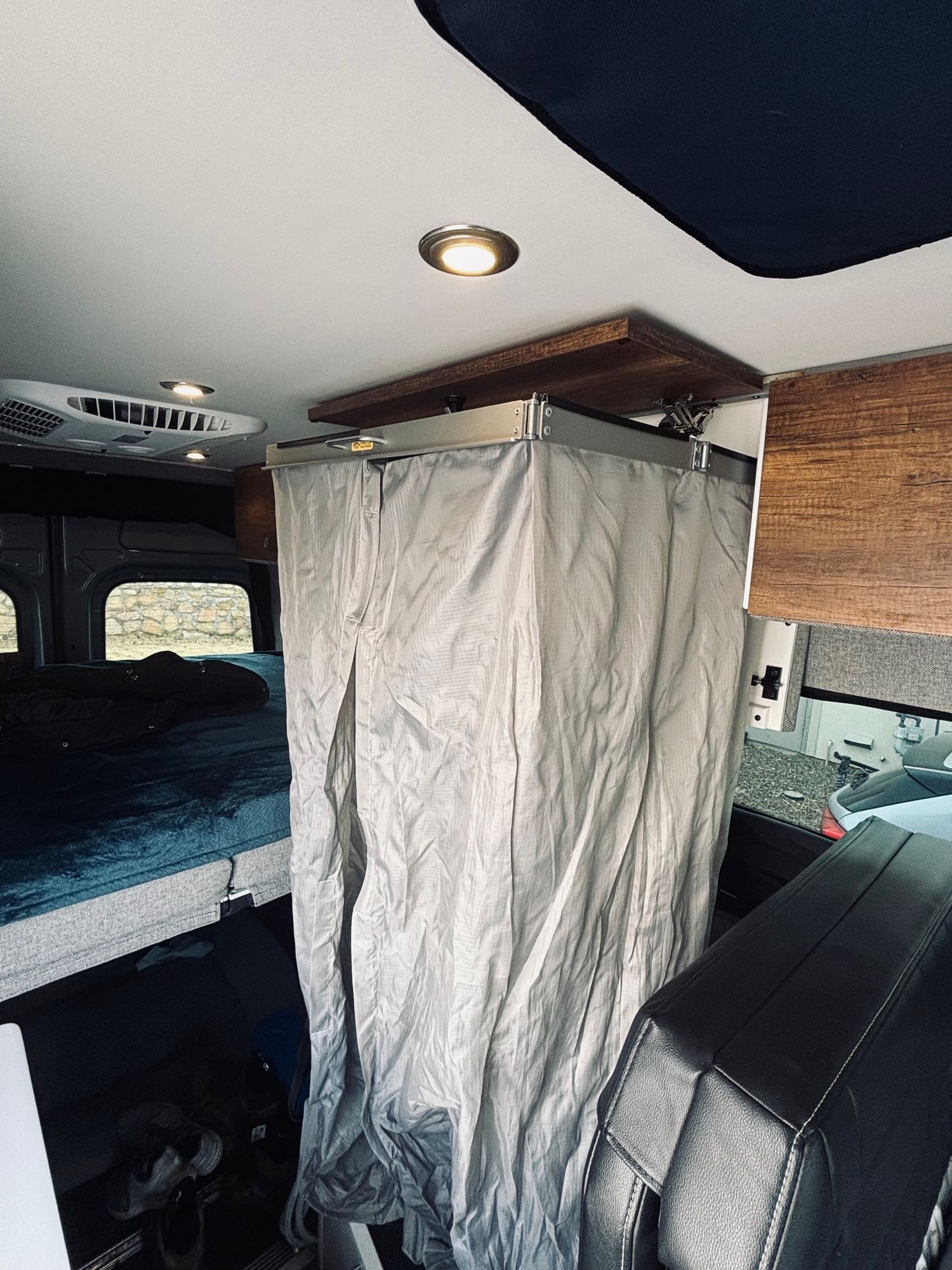 Explore this RV rental's compact interior with a cozy bed & a convenient shower curtain.. Storyteller Overland Stealth Storyteller Overland Class B 2021