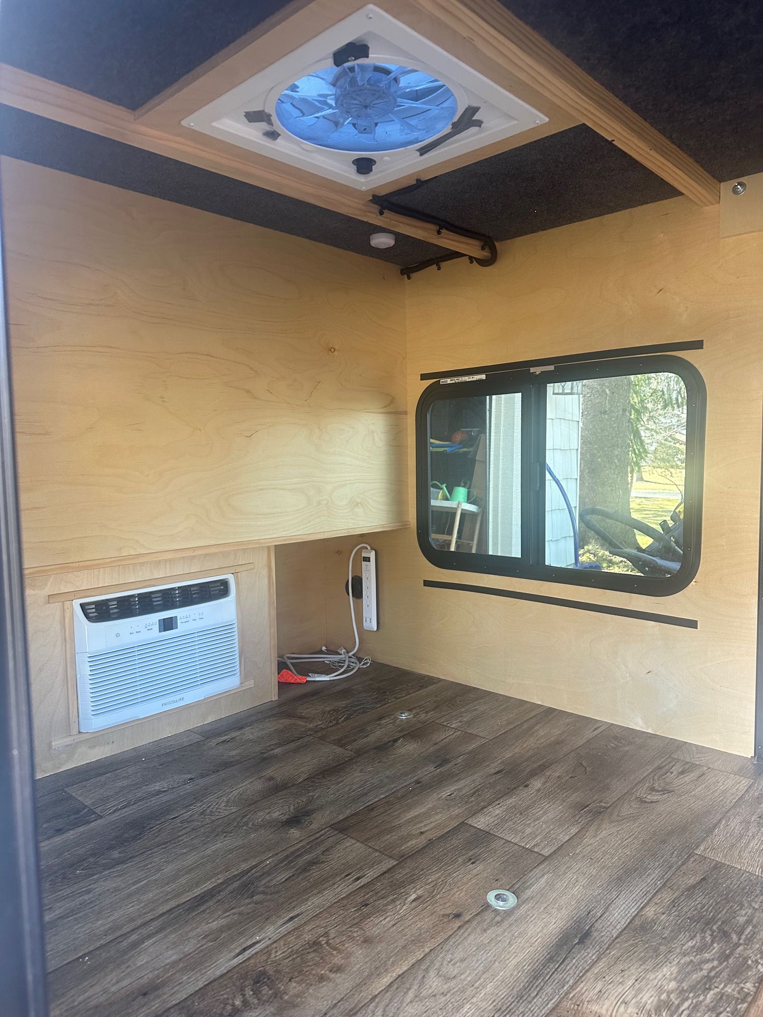 Clean RV rental interior: wood walls, AC, ceiling fan, and window. Ready for your comfortable travels.. Outbound Extreme 2021