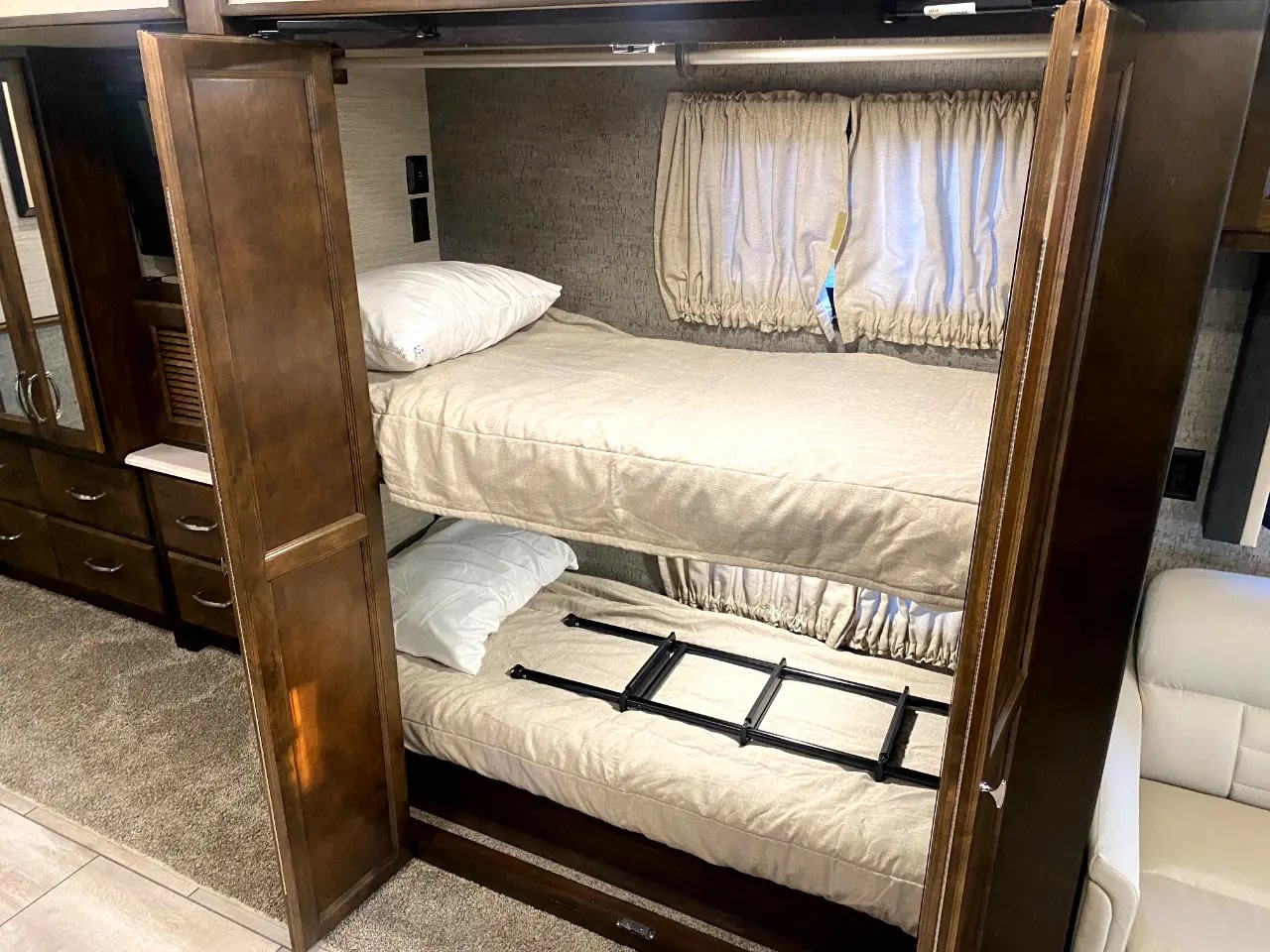 RV rental features stacked bunk beds with a ladder for easy access, and adjacent storage, offering efficient sleeping space.. Tiffin Motorhomes Allegro Open Road 2020