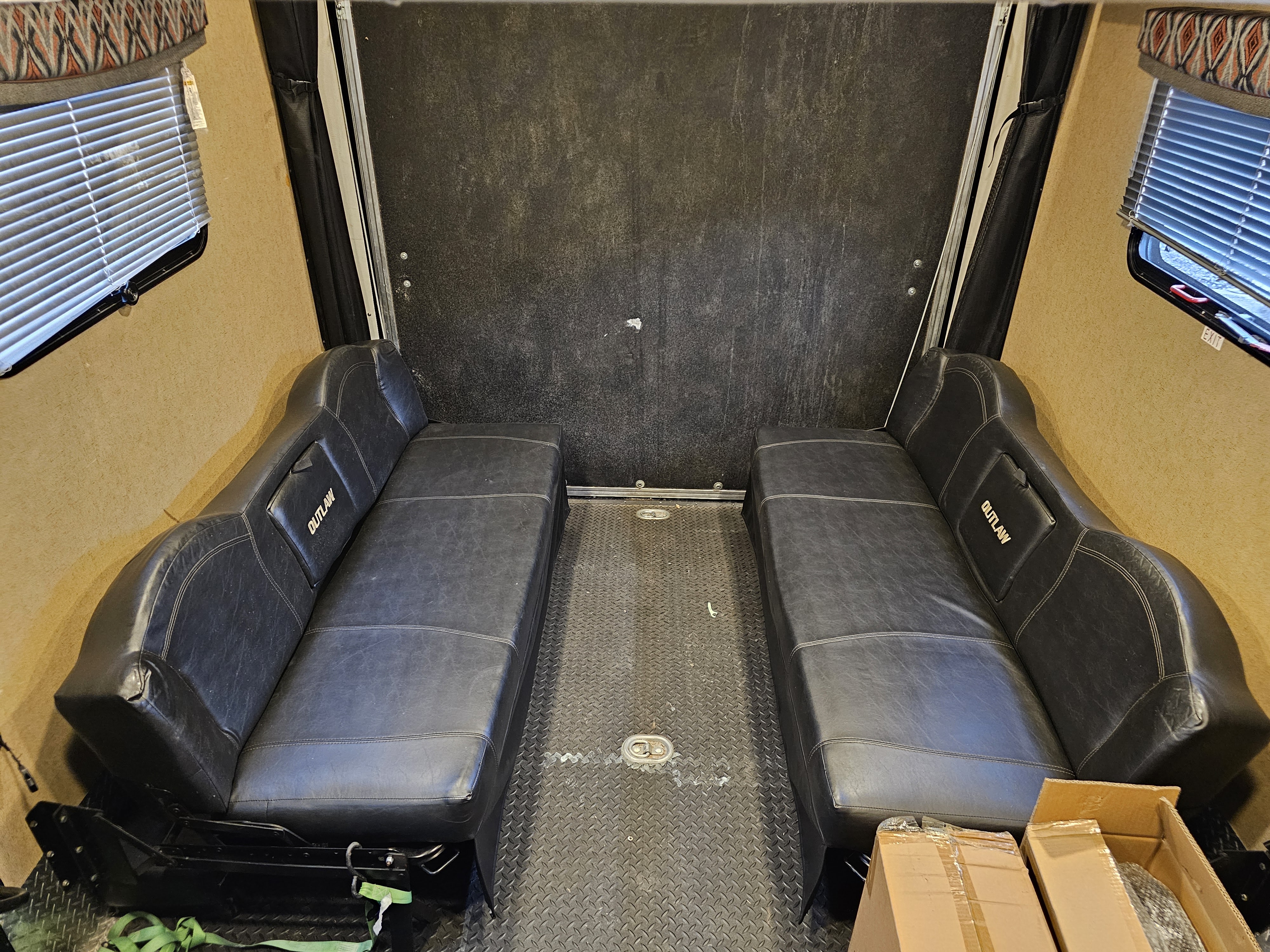 RV rental toy hauler garage with two 'OUTLAW' branded black vinyl benches and sturdy diamond plate flooring.. Thor Outlaw 2016