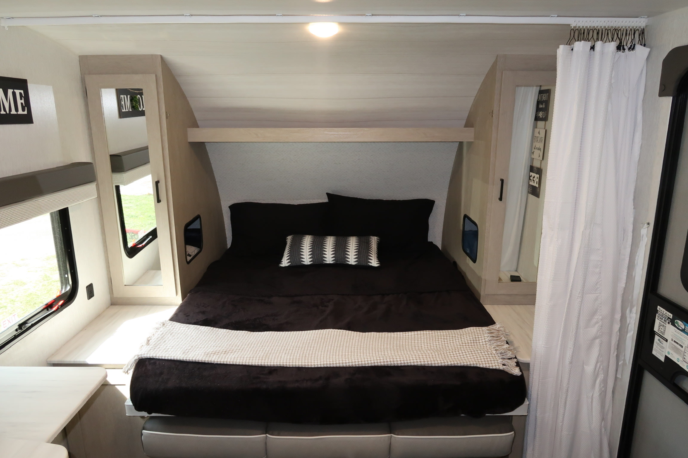 Experience comfort in this RV rental bedroom. Features include a cozy bed, side storage, and a privacy curtain. Ideal for travel.. Forest River Salem Cruise Lite Platinum 2023