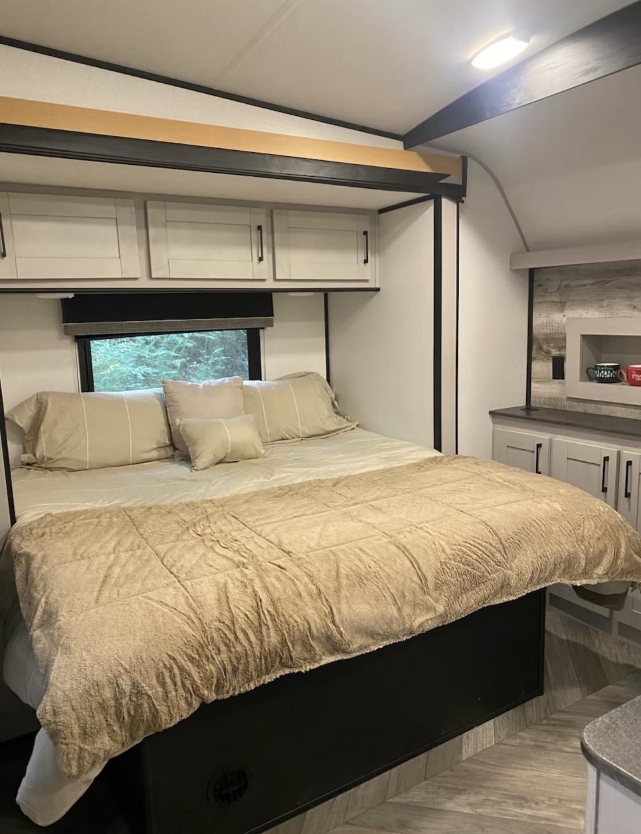 Comfortable RV rental bedroom with a large bed, storage cabinets, and a window view, ideal for travel.. Heartland Torque 2022