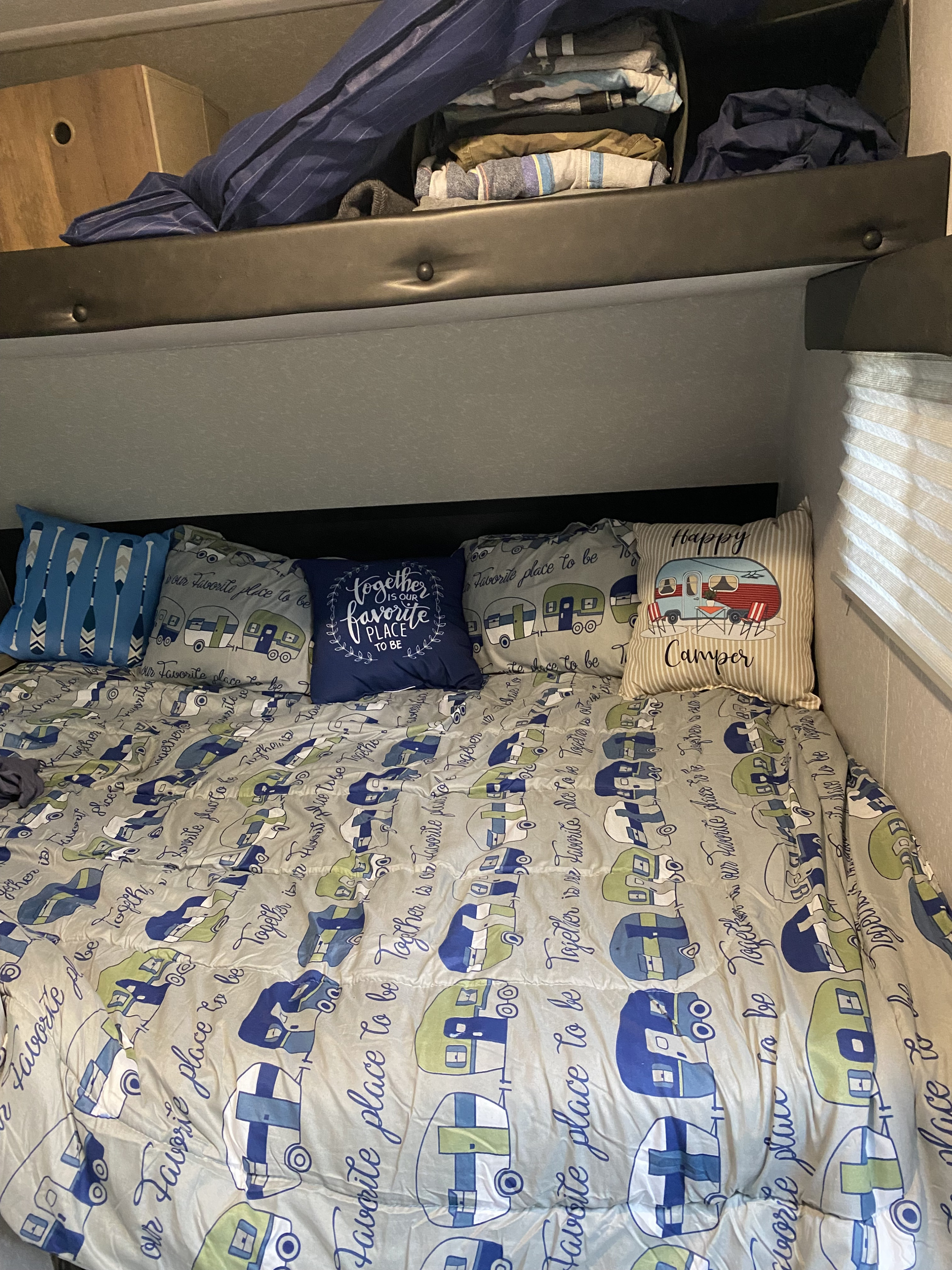 A cozy RV bunk bed with camper-themed bedding and storage above, perfect for an RV rental adventure.. Forest River Cherokee Wolf Pup 2022