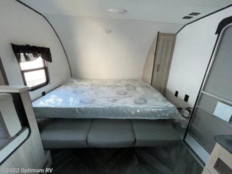 Compact RV rental bedroom featuring a new mattress, window, and versatile sofa seating below. Ideal for your next journey.. Heartland RVs Prowler Lynx 2022