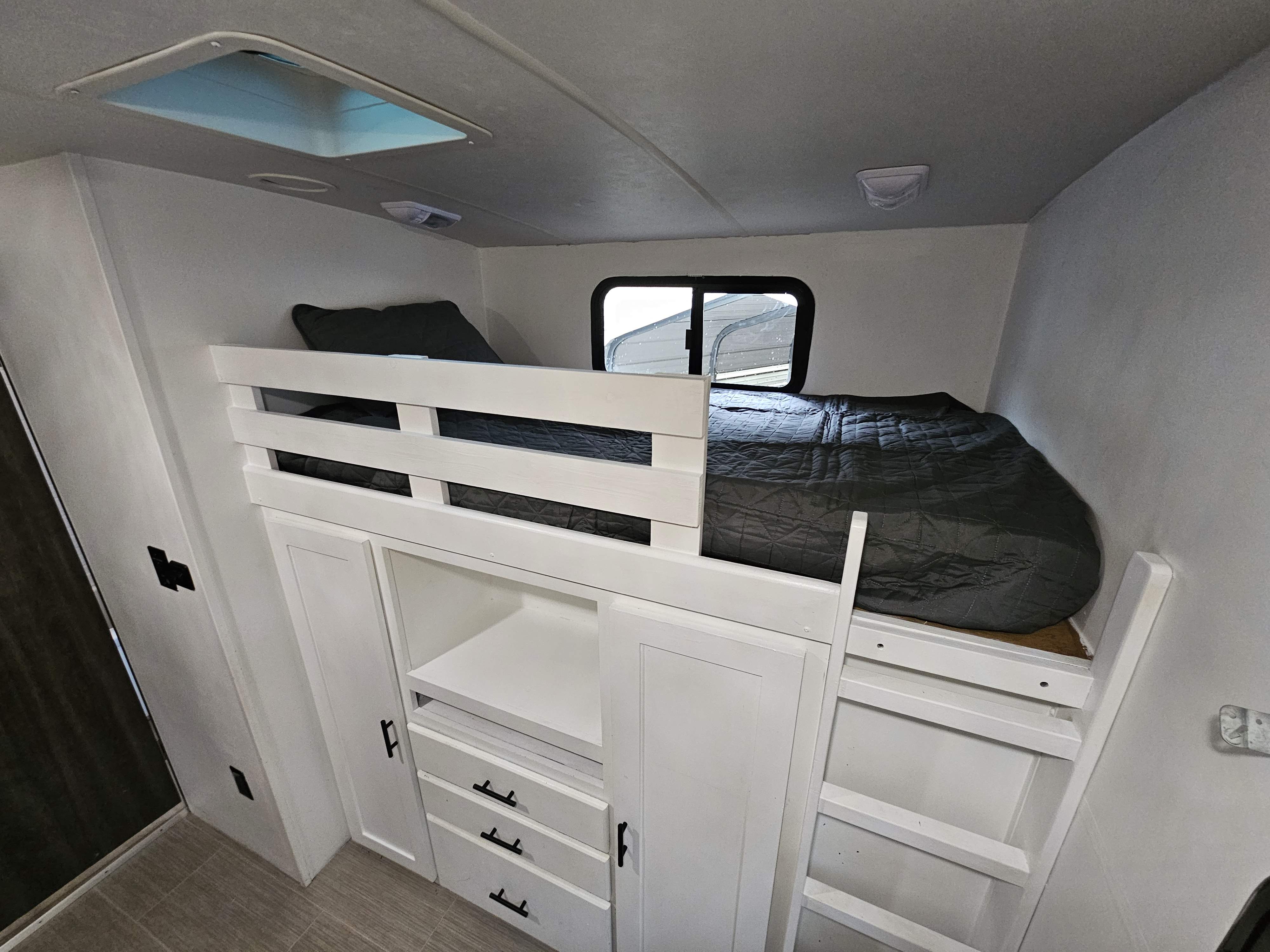 Bright RV rental interior with white bunk beds, ample storage, and a skylight, ideal for family travel.. Highland Ridge RV Open Range Ultra Lite 2017
