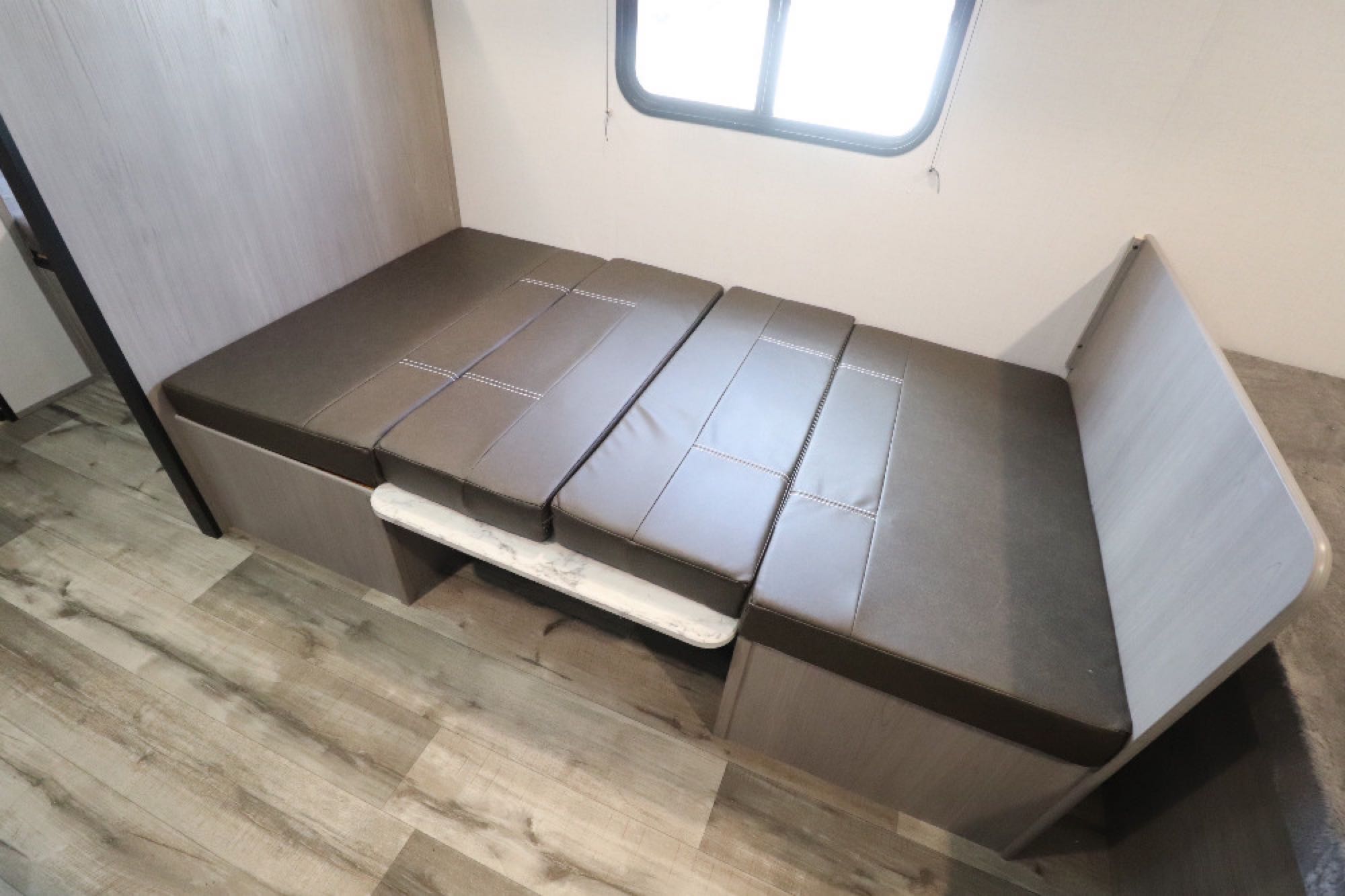 Cozy RV rental interior with convertible dinette sleeper and light wood flooring, perfect for your next adventure.. Coleman LT17B 2024