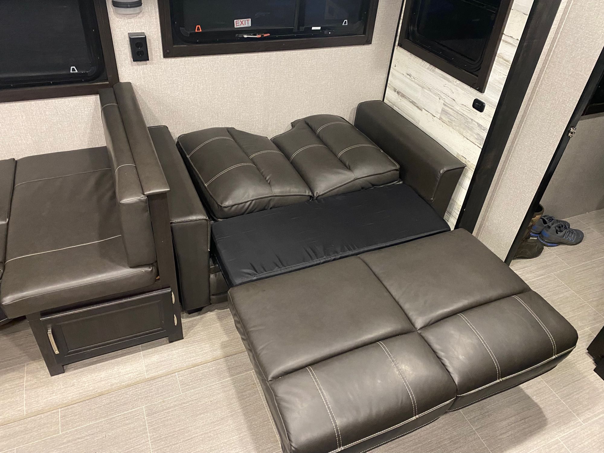RV rental: view of a dark, modular sofa converting to a bed in the vehicle's compact interior.. Jayco White Hawk 2021