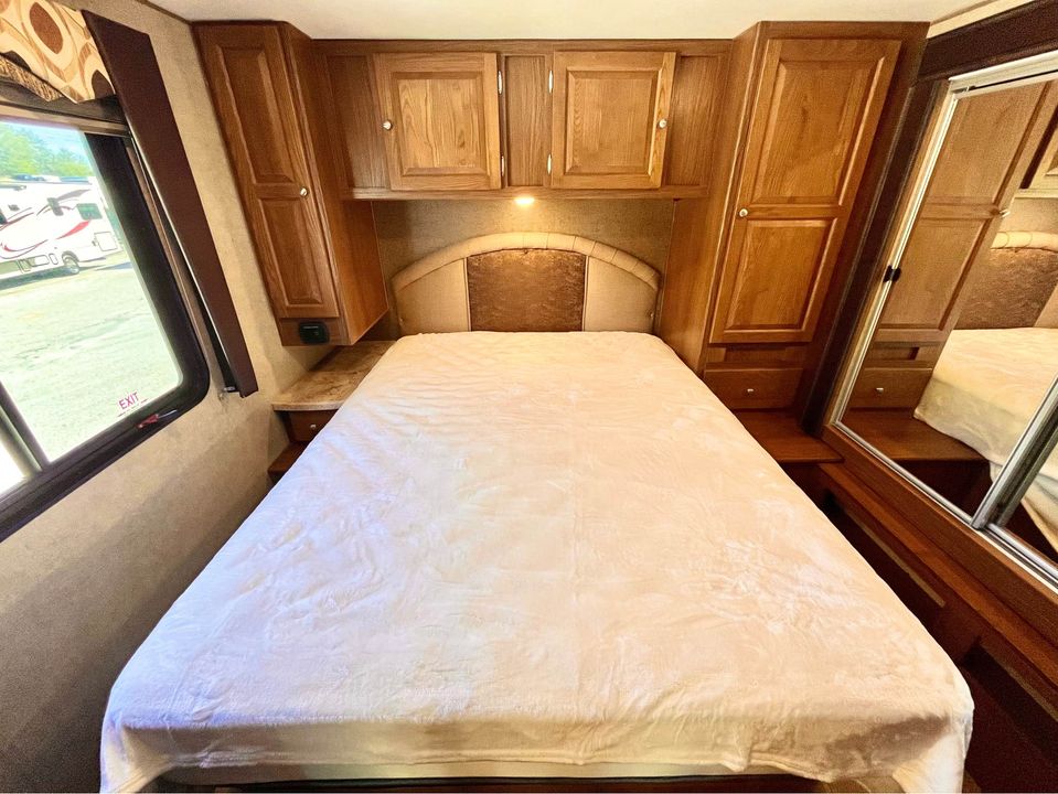 Comfortable RV rental bedroom with spacious bed, ample storage, and natural light.. Coachmen Leprechaun 2017