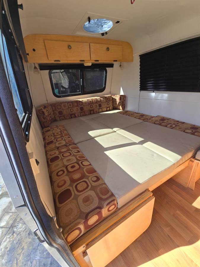 RV rental: Cozy camper interior featuring a convertible bed/seating area with overhead cabinets.. Little Guy Little Guy Trailer 2018