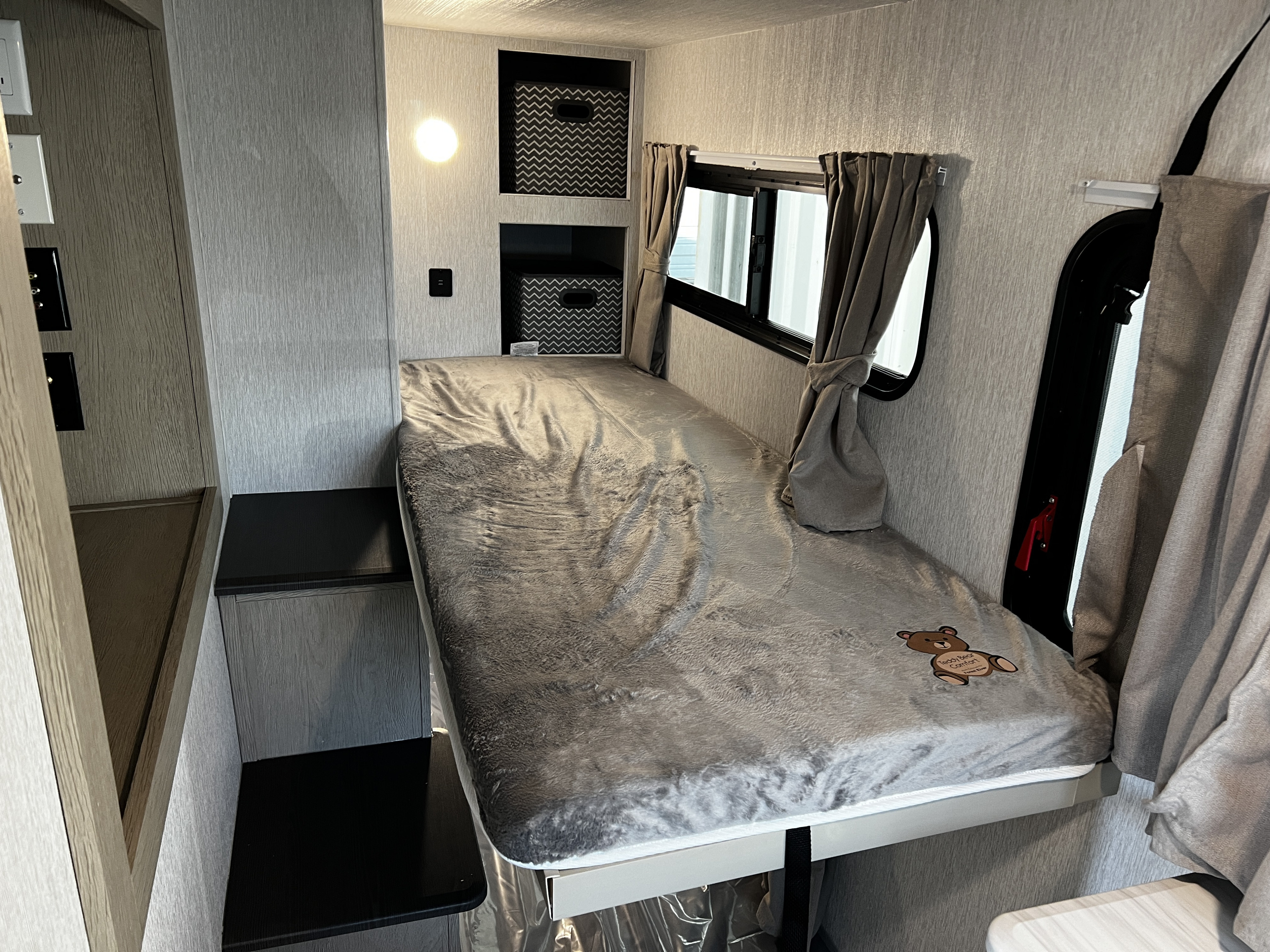 RV rental: Interior showing a cozy bunk bed with gray blanket, storage cubbies, and window with curtains.. Forest River 29 View 2024