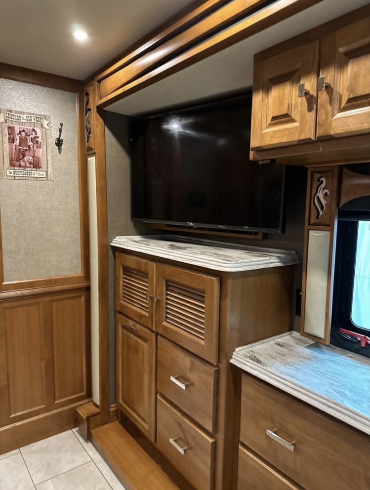 Inside an RV rental: Enjoy the mounted TV, plentiful wood cabinets, and counters in this spacious interior for your travels.. Tiffin Motorhomes Phaeton 2019