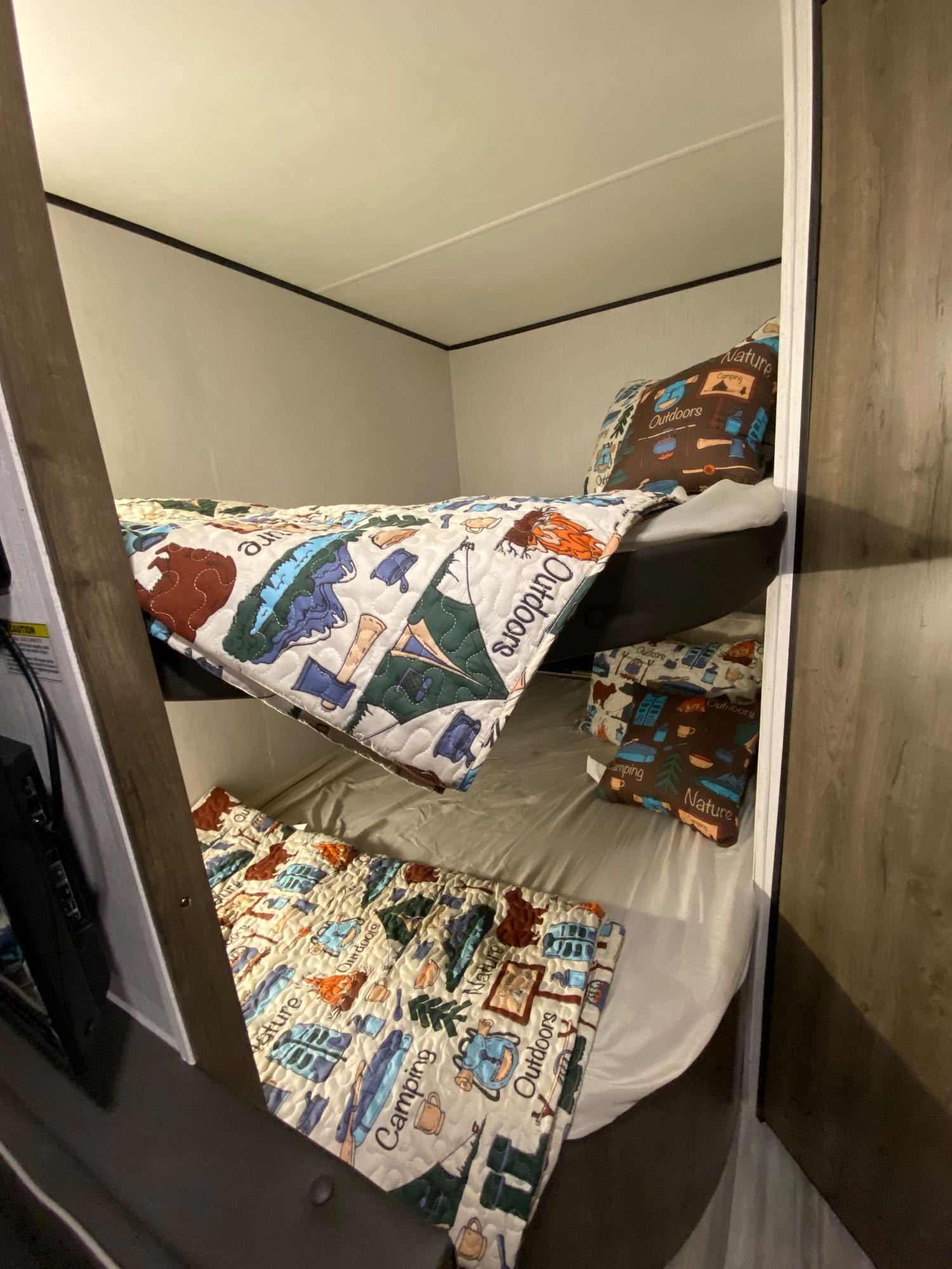 Cozy RV rental bunk beds with nature & outdoors camping bedding, ideal for family travel adventures.. Heartland RVs Pioneer 2021