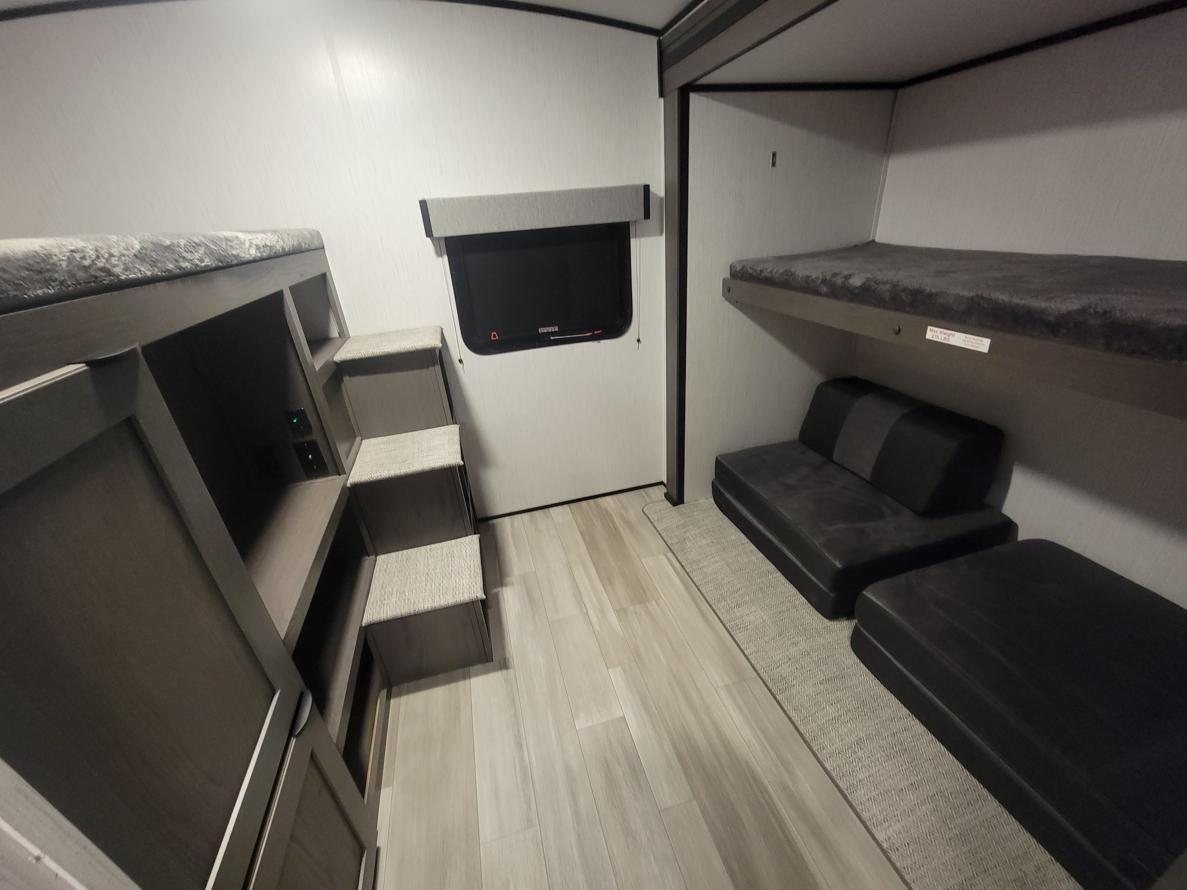 Spacious rv rental bunk room with built-in steps, shelving with power outlets, and modular seating, ideal for families.. Cruiser Rv Corp MPG 31BH 2023