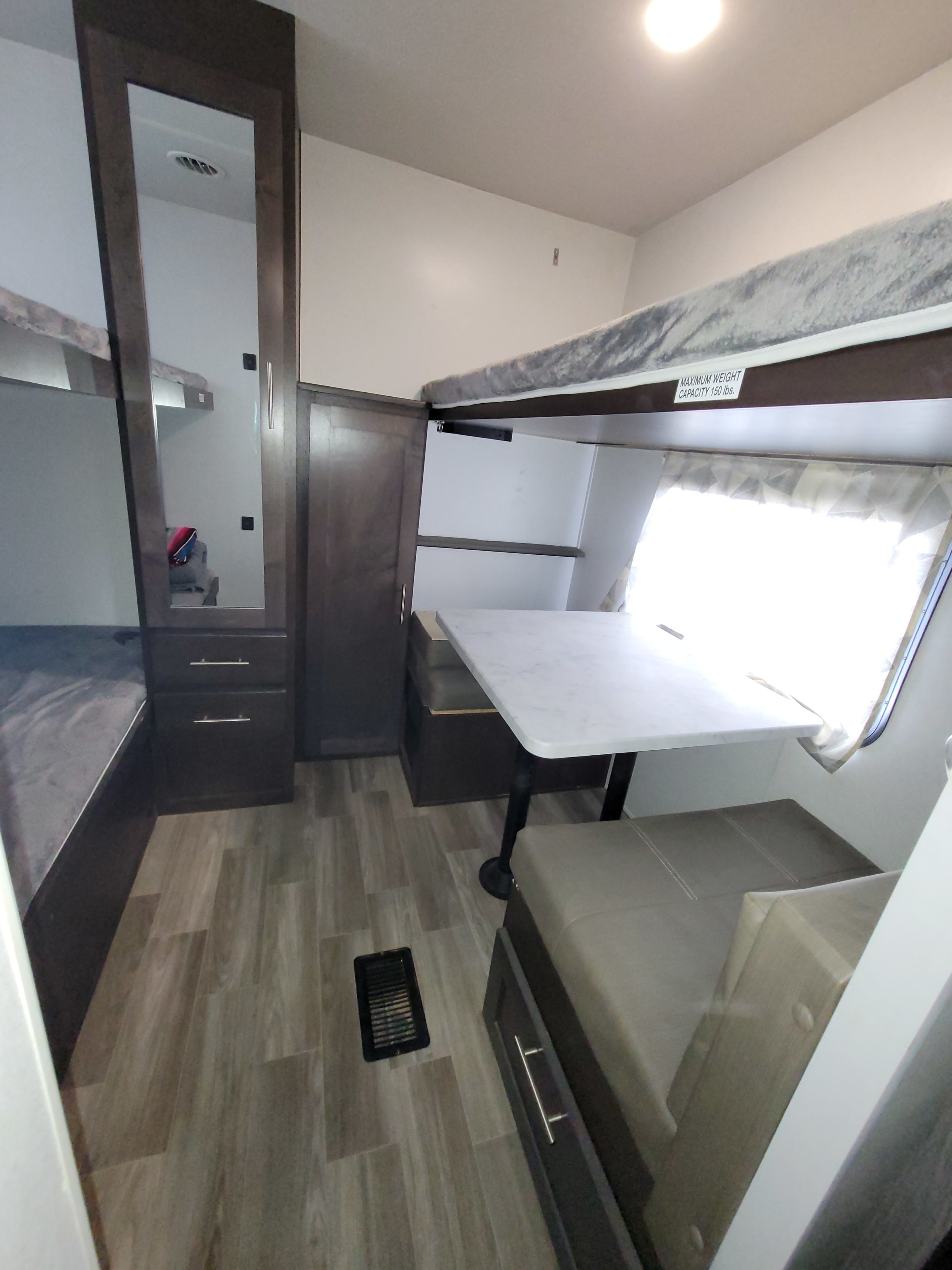 Compact RV rental bunkhouse area with a dinette, bunk beds, and mirrored storage, designed for efficient use of space.. Forest River Salem 2020