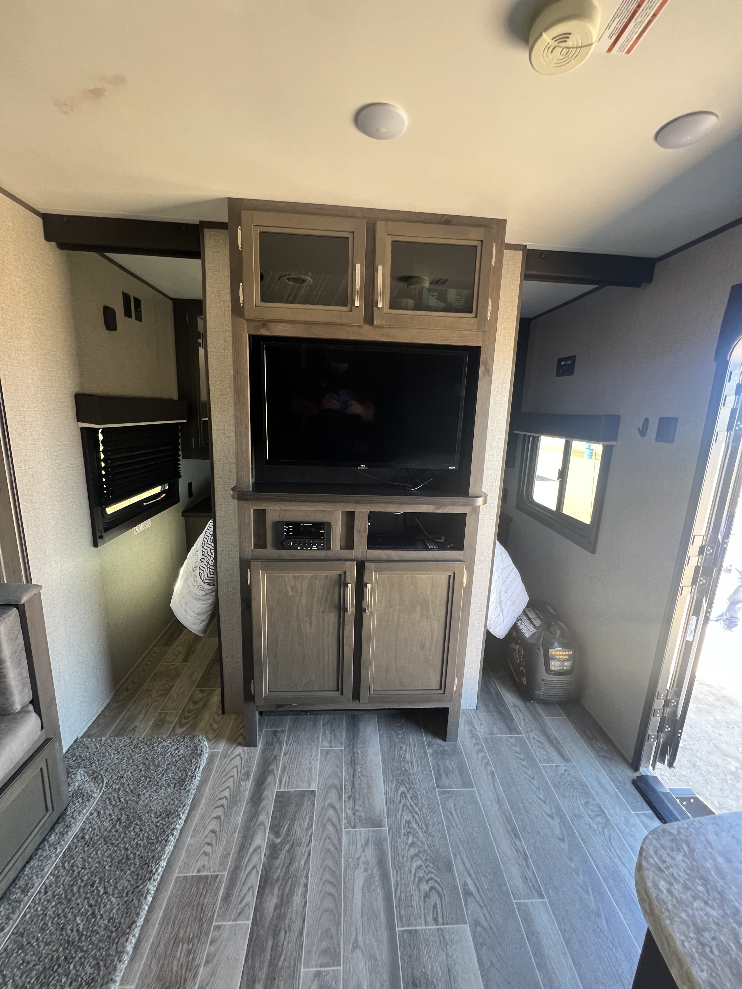RV rental interior showing a living area with an entertainment center, wood flooring, and a compact design.. Jayco Jay Flight SLX 2021