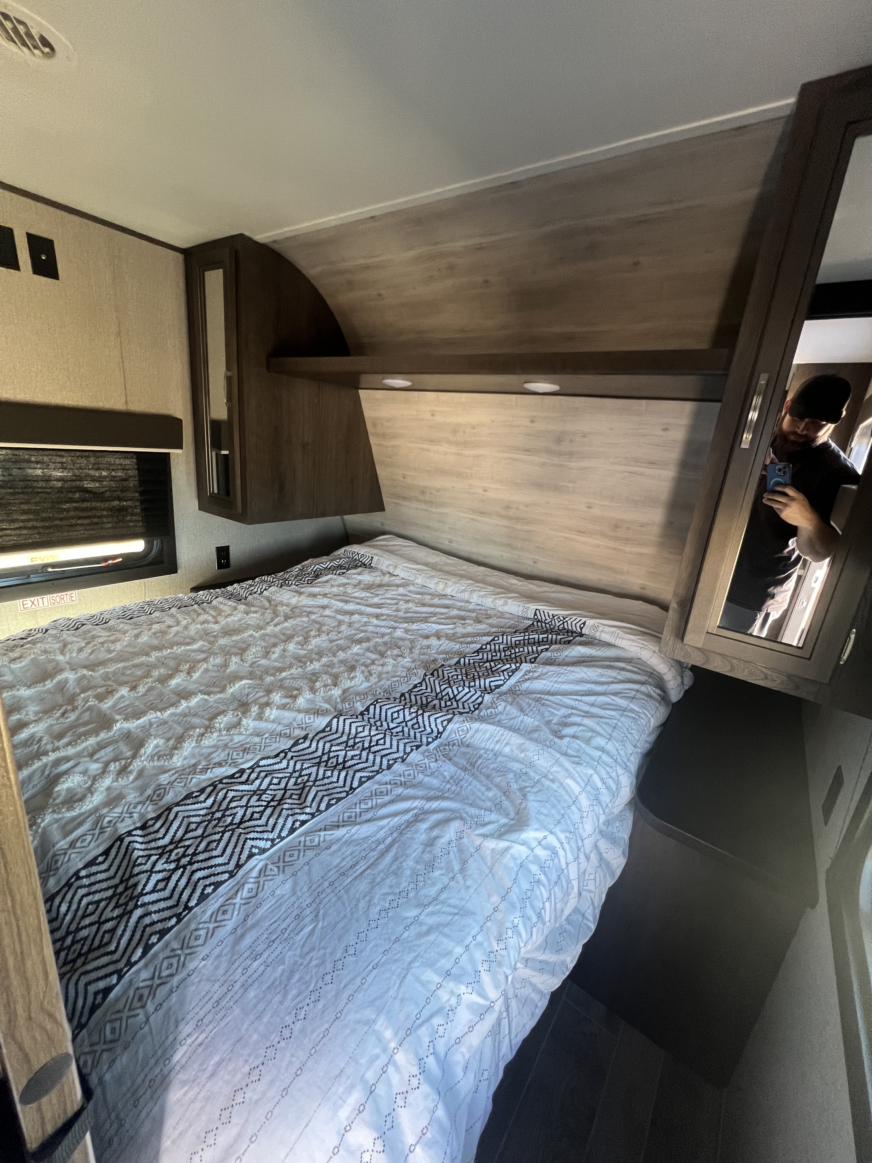 Cozy RV rental bedroom with geometric patterned bedding, overhead storage, and a window for natural light.. Jayco Jay Flight SLX 2021