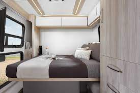 This RV rental interior showcases a modern, comfortable bedroom with a spacious bed and storage, ideal for camper travel.. Leisure Travel Vans Wonder 2021