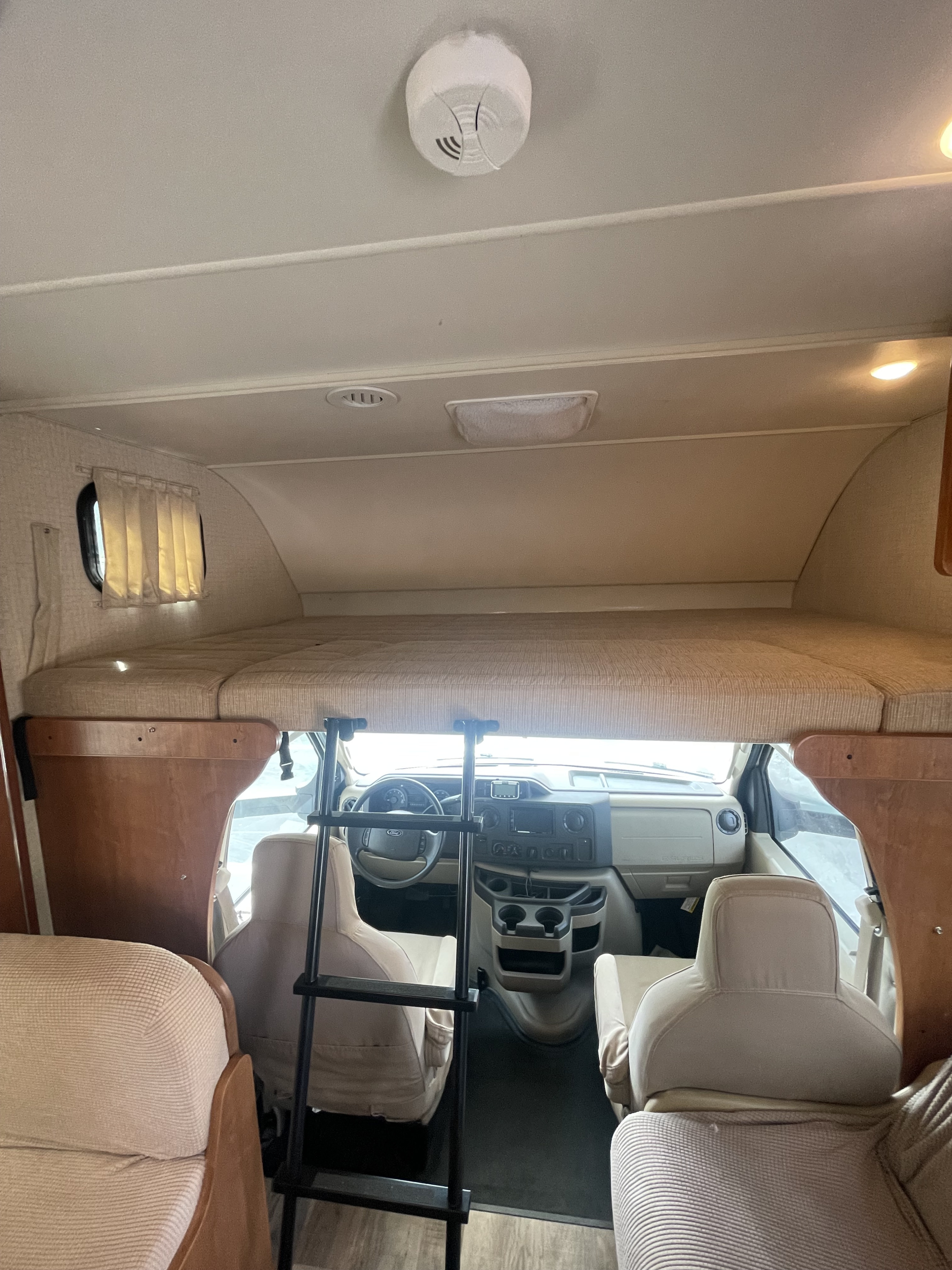 RV rental interior: Cab-over bunk with ladder, revealing the driver's cockpit below.. Winnebago Minnie Winnie 2018