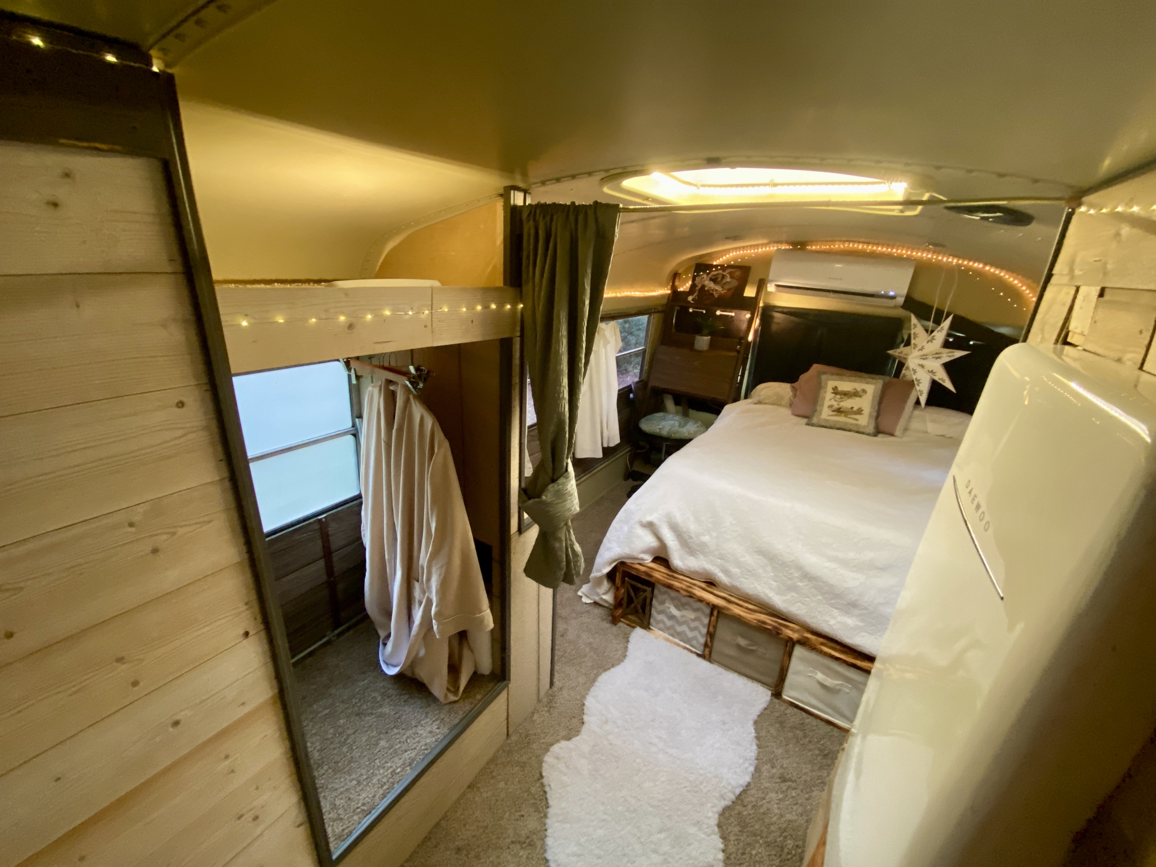 Discover a charming RV rental interior: a cozy bedroom with wood paneling, string lights, and storage. Perfect for adventurers!. International 510A 1996
