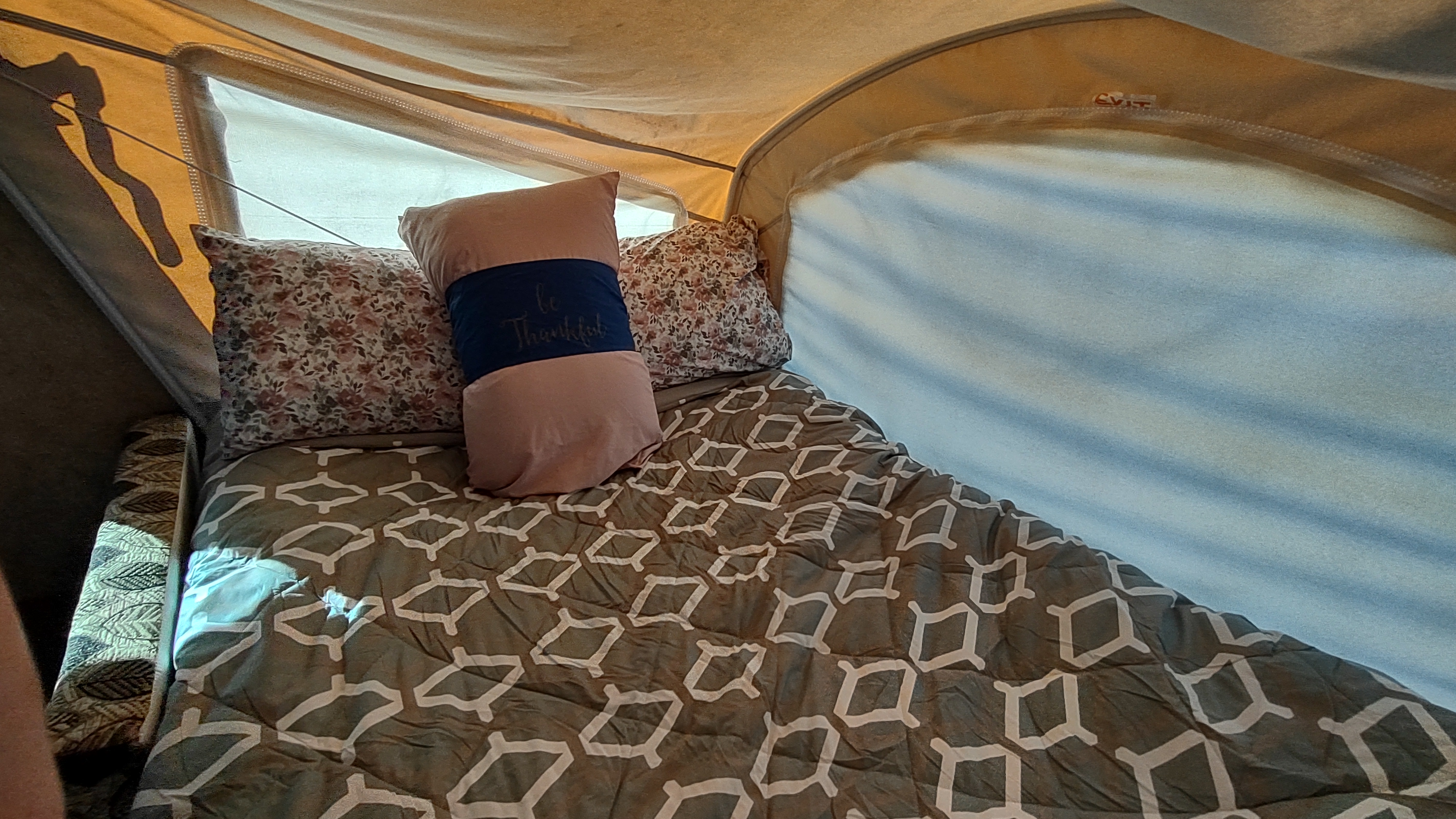 Cozy RV rental interior showing a bed with patterned bedding and pillows, one reading 'Be Thankful'.. Clipper Clipper Trailer 2016