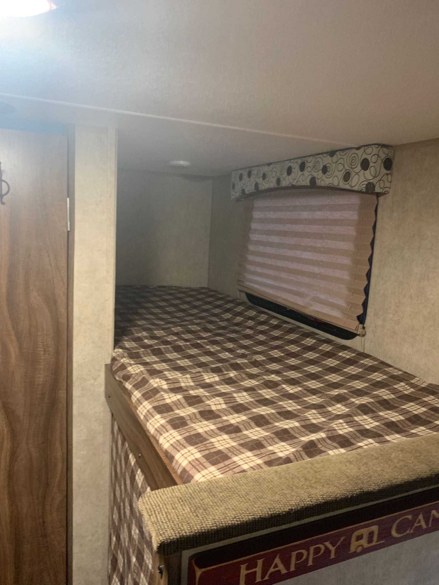 Cozy RV rental bunk bedroom with plaid bedding and window, ready for your camping adventure.. Coachmen Clipper 2016