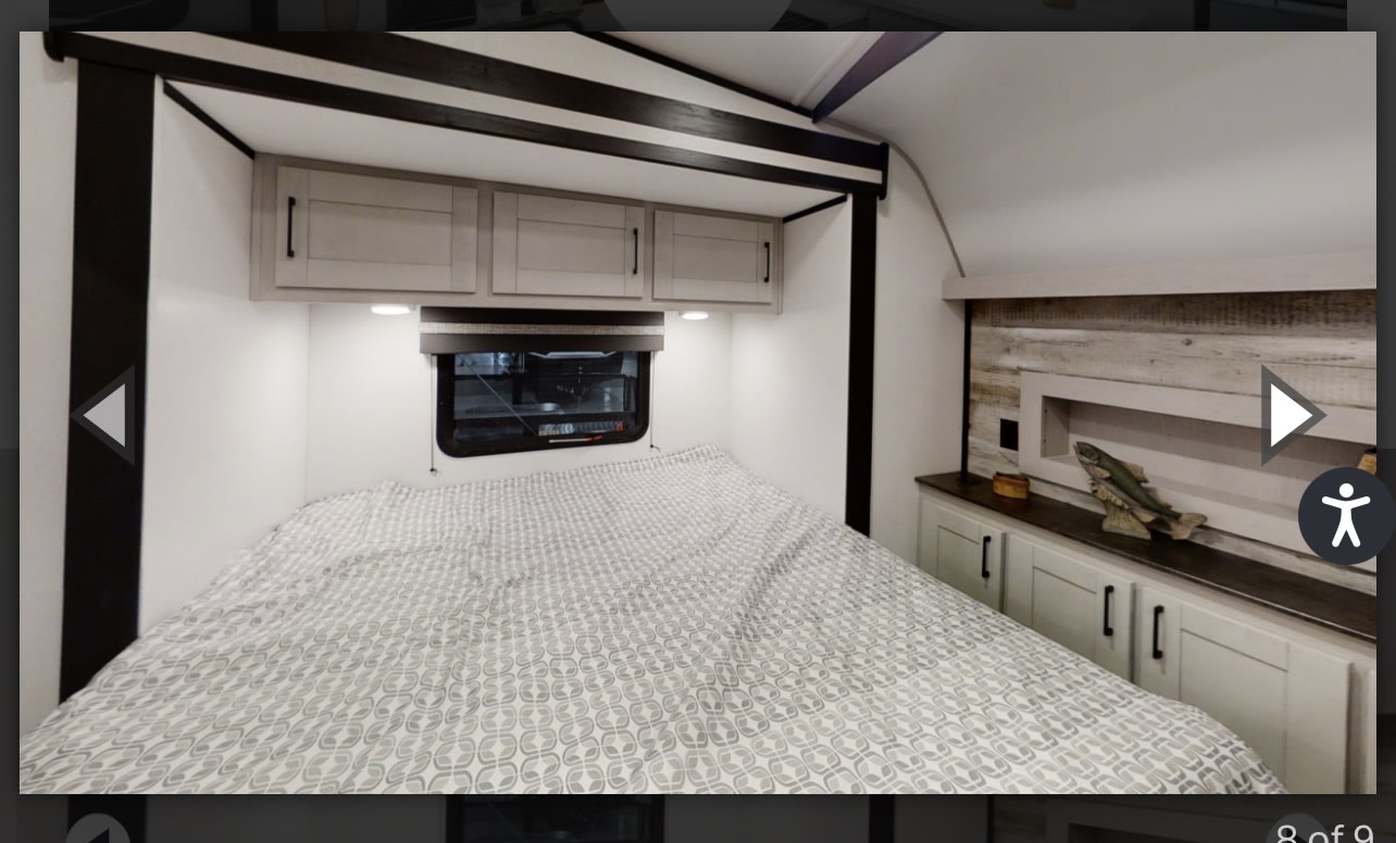 This RV rental bedroom offers a comfortable bed, overhead cabinets, and built-in storage. Ideal for camping and travel.. Heartland Torque 2022