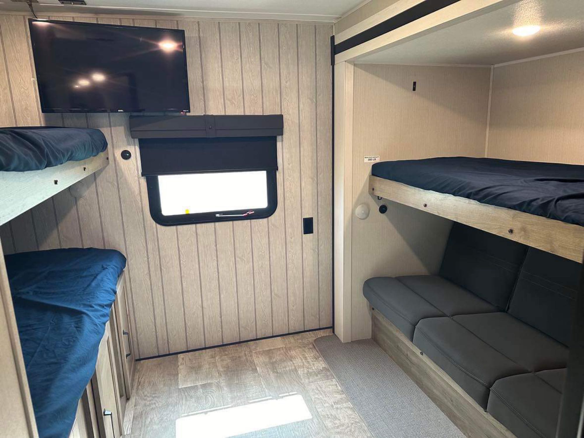 Cozy RV rental interior: bunk beds, TV, and a flexible seating area, perfect for family adventures on the road.. Forest River Palomino Puma 2024