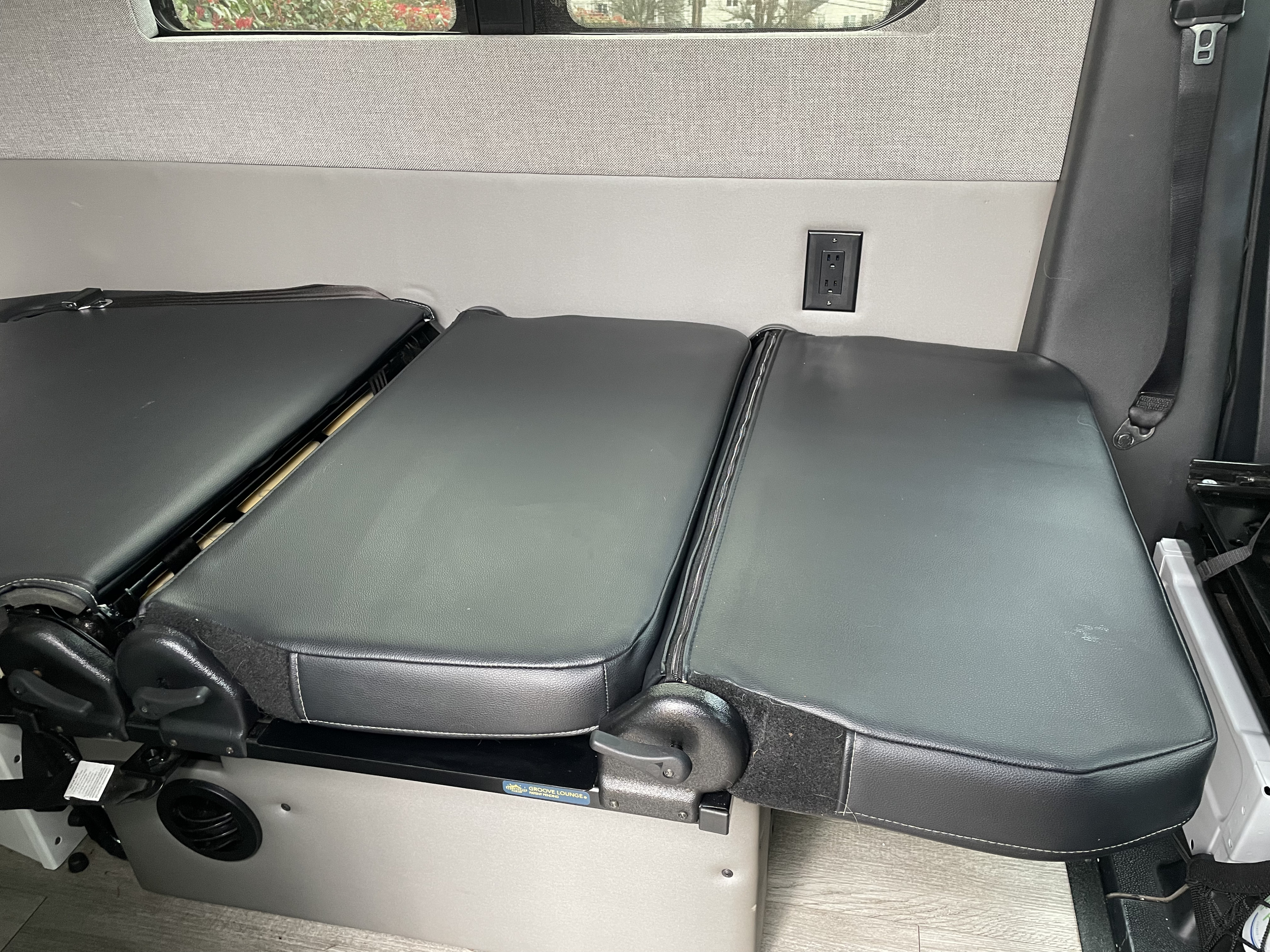 This RV rental interior features convertible black bench seats that fold out for flexible living space, equipped with a convenient power outlet.. Storyteller Overland Storyteller Overland Class B 2020