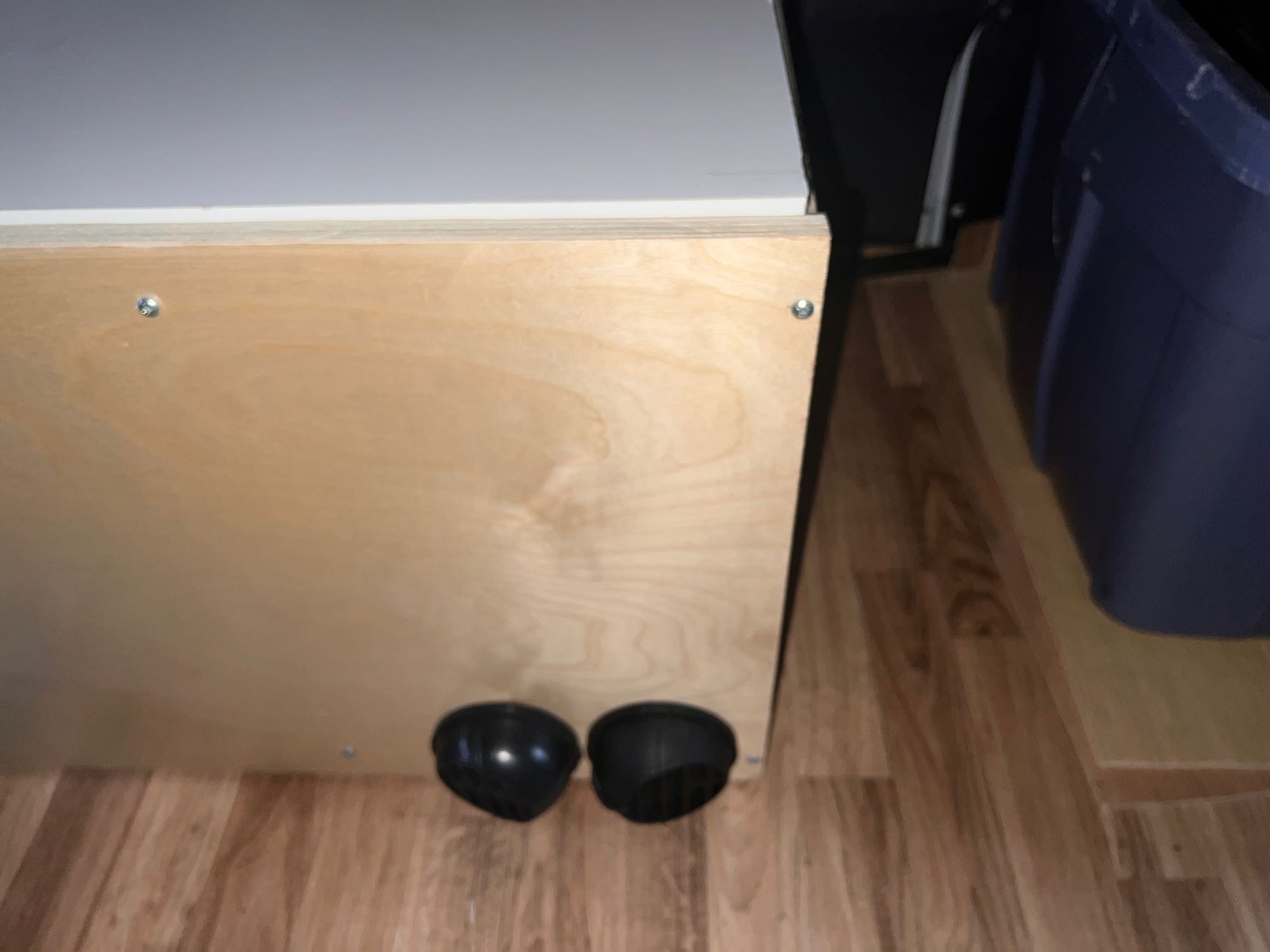 RV rental: Light wooden custom-built storage or bed base with two black circular vents, on wood flooring.. Ram Promaster 2019