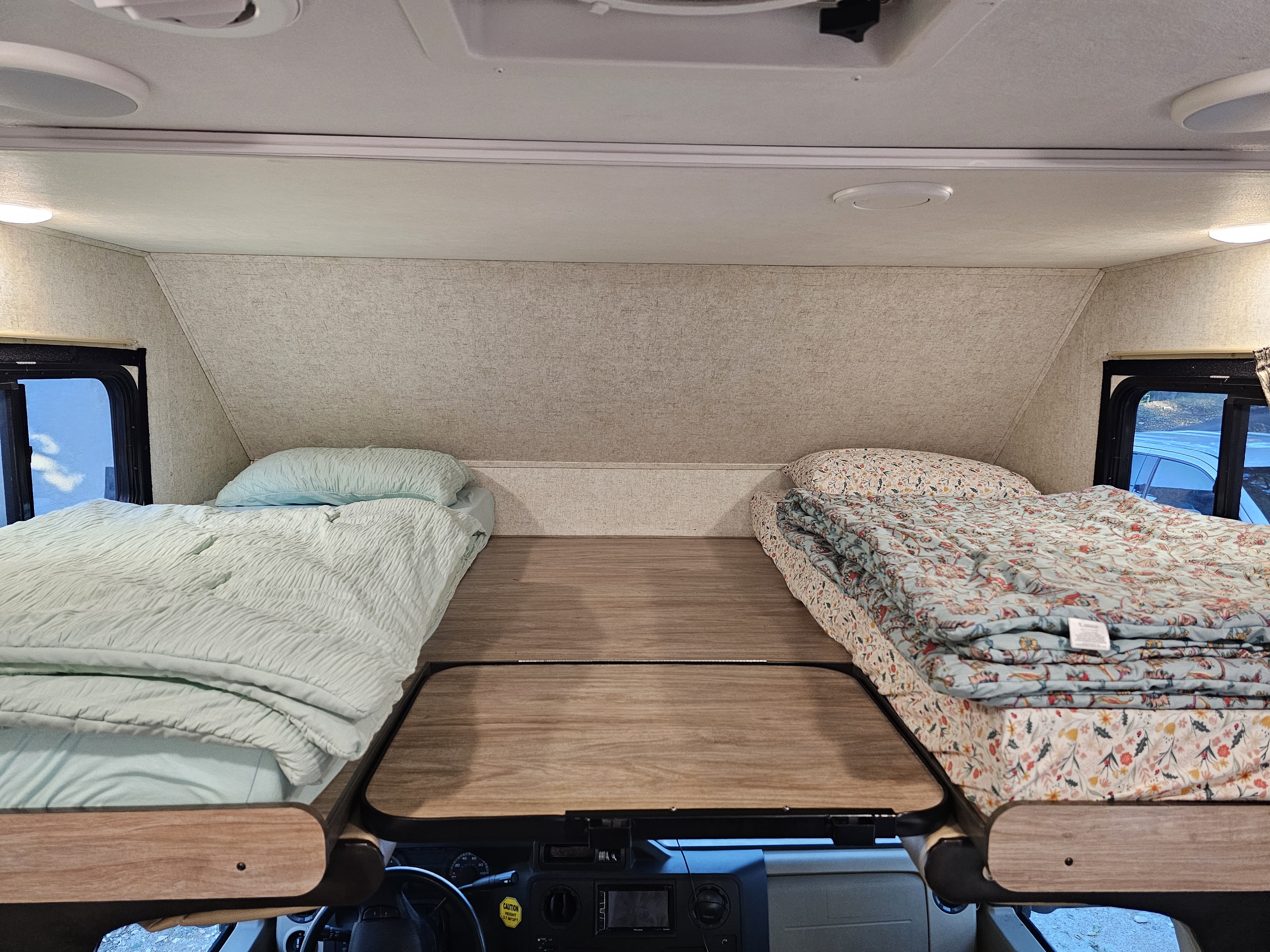 Two comfy beds in the overhead bunk of an RV rental, a cozy sleeping space above the cab.. Forest River Sunseeker 2019
