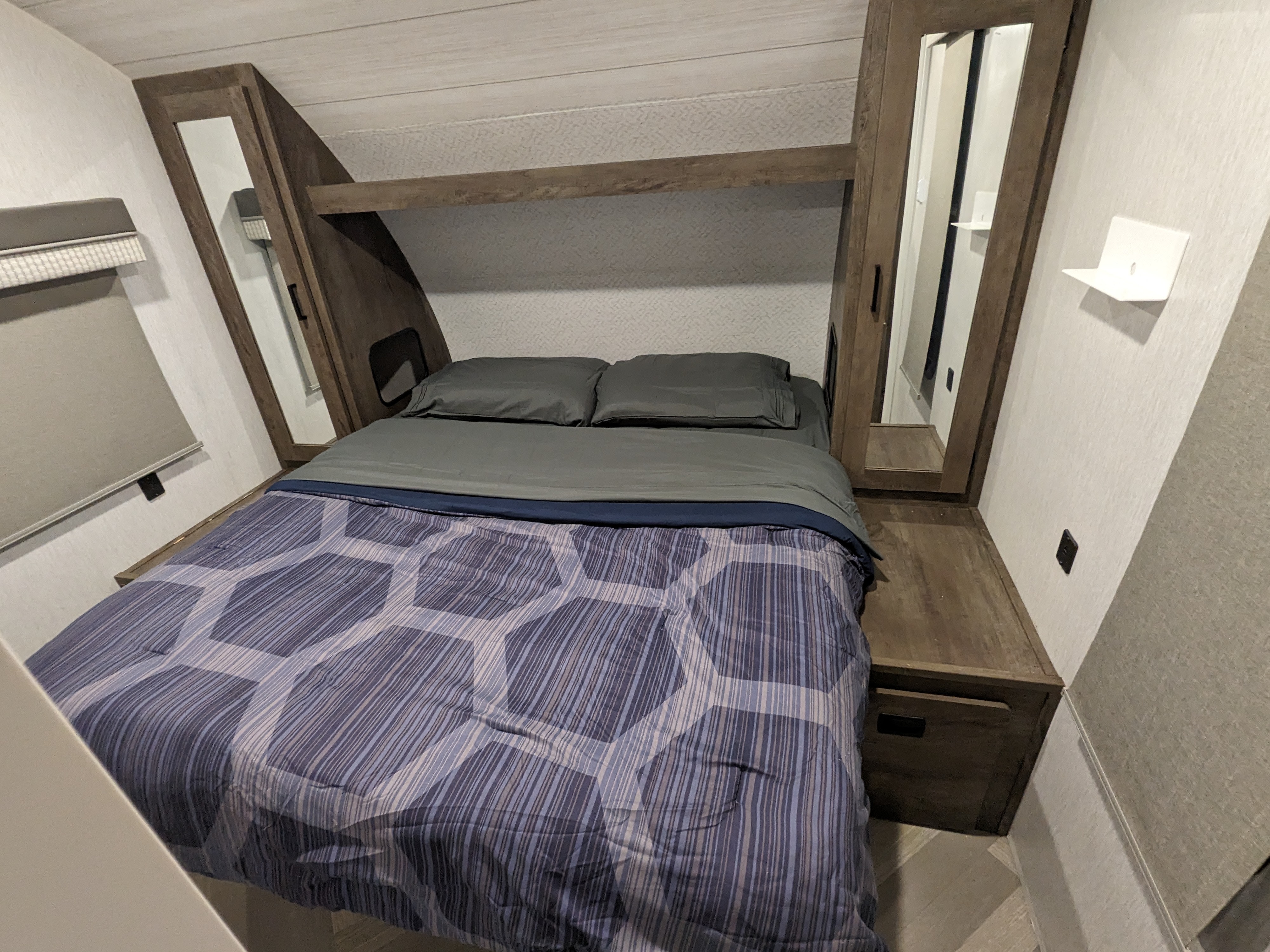 Compact RV rental bedroom. Features a comfortable bed, mirrored wardrobes, and smart storage, perfect for travel.. Forest River Salem Cruise Lite 2022