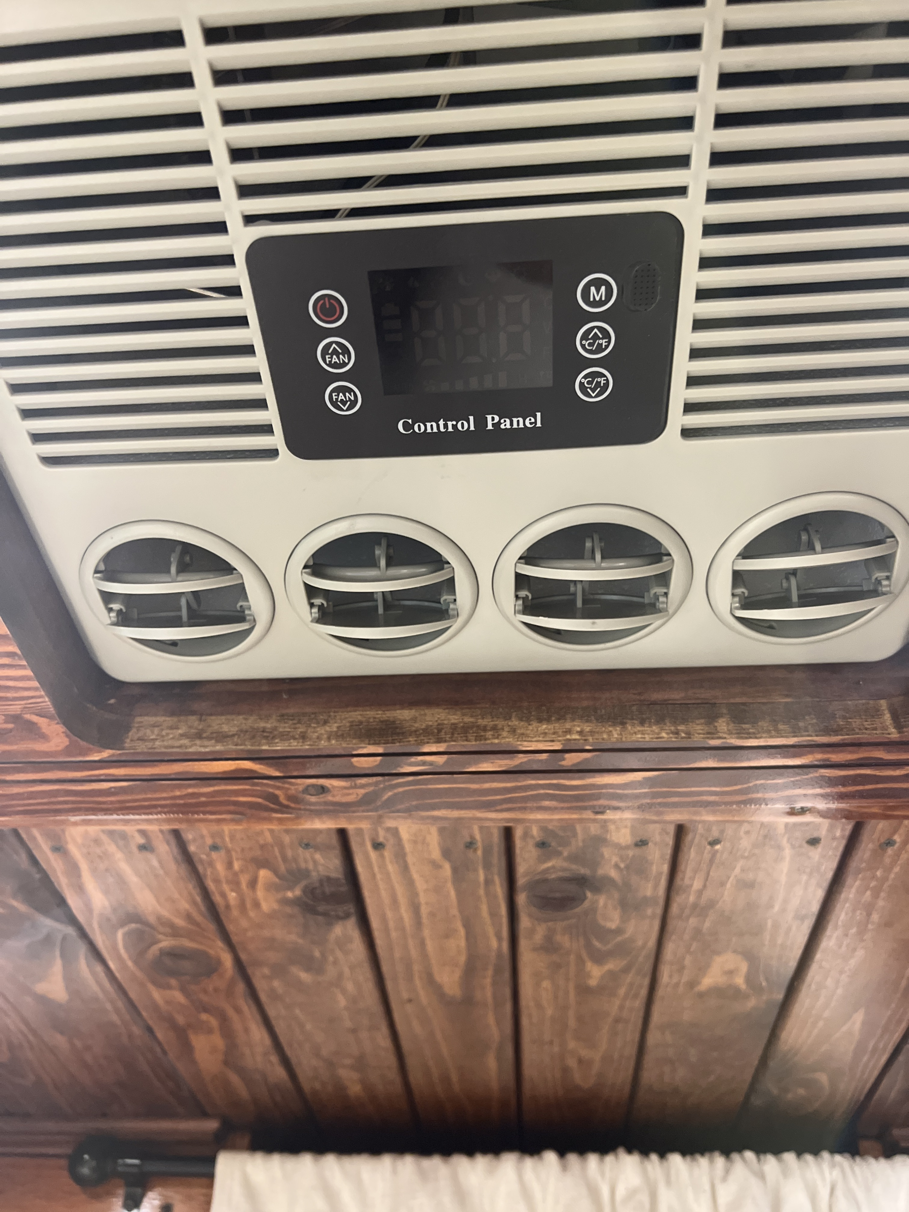 Overhead RV rental AC unit with a digital control panel, adjustable fan settings, and four circular air vents on a wooden ceiling.. Mercedes-Benz Sprinter 2016
