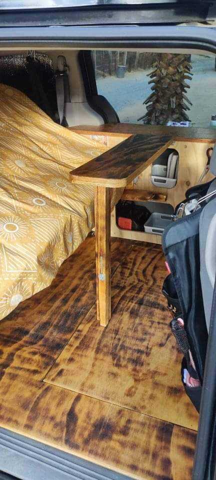 Cozy DIY van conversion with bed, table, and storage visible. Great for an RV rental or mobile living.. Dodge Grand Caravan 2009