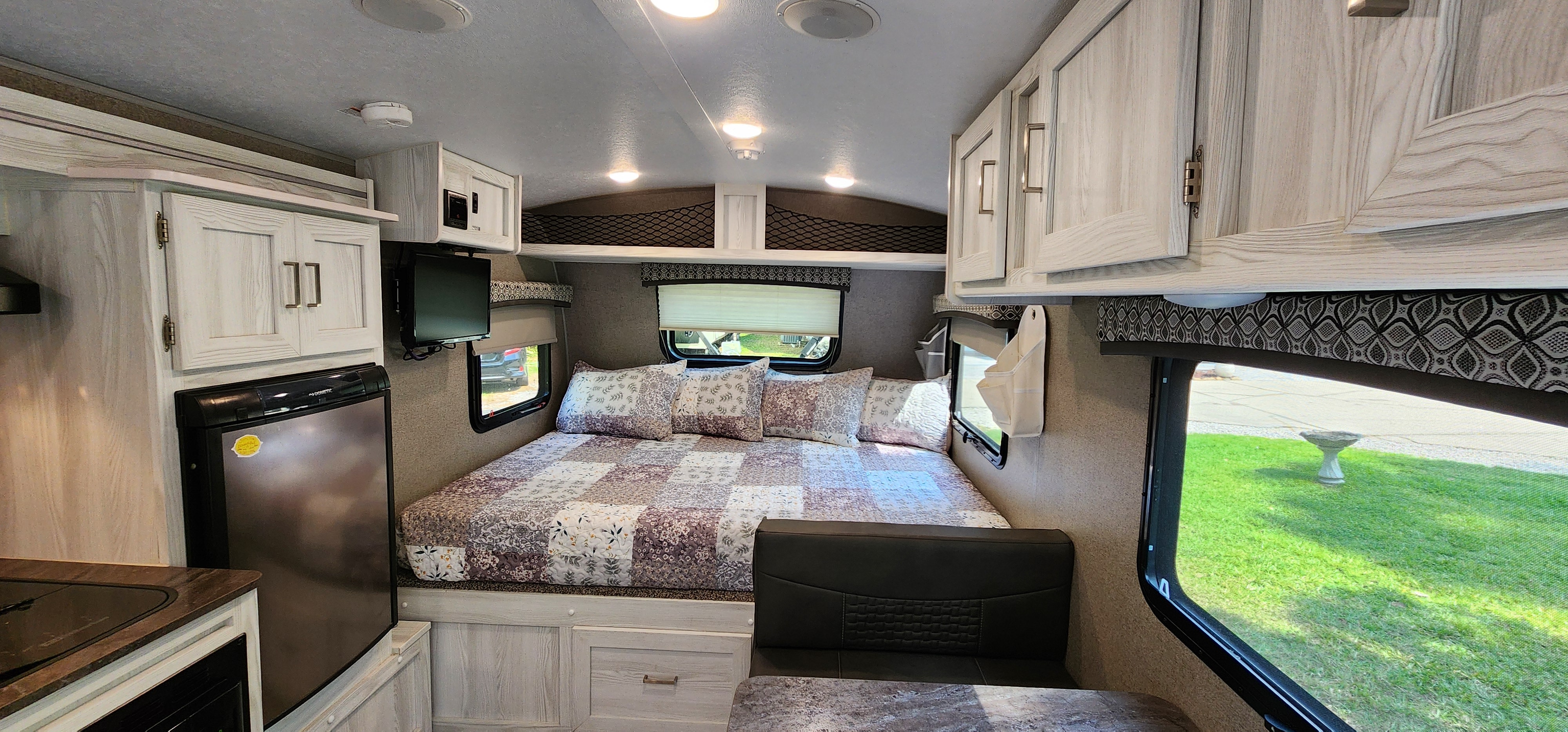 Cozy RV rental interior featuring a spacious bed, kitchen, and dining nook.. Forest River Flagstaff E-Pro 2020