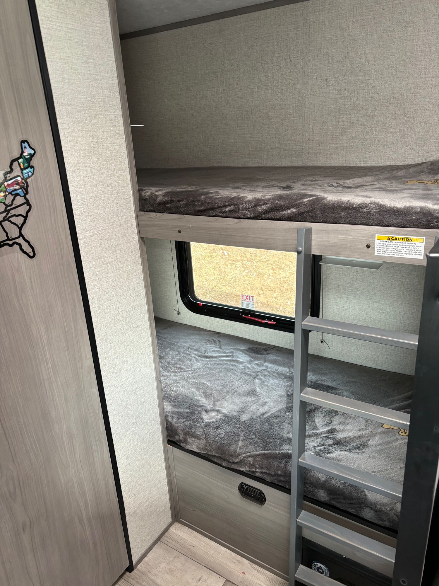 rv rental bunk beds with soft grey blankets & ladder. Cozy RV interior with a window for comfort.. Dutchmen Coleman Lantern LT 2023