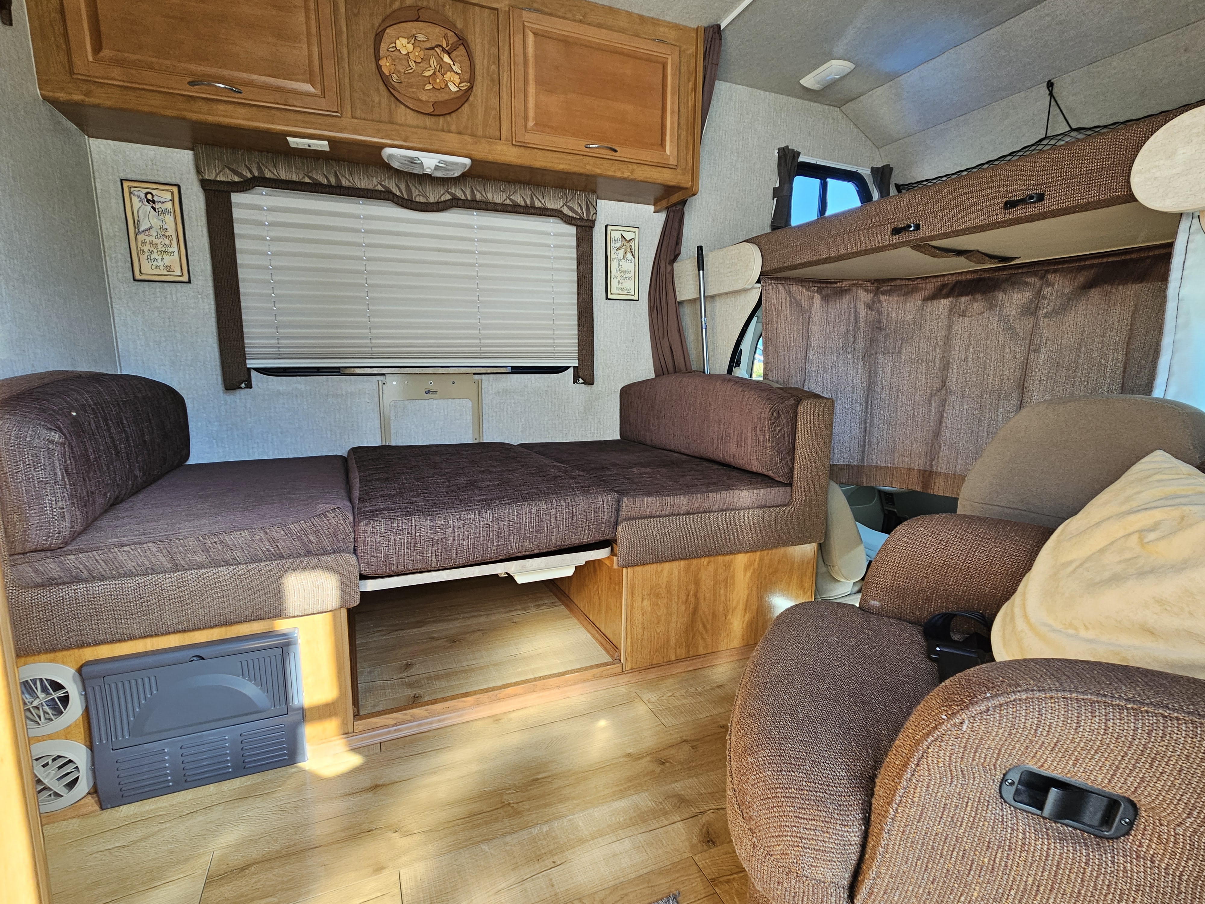 This RV rental interior features a versatile sofa bed, overhead bunk, and ample cabinetry, offering a comfortable space for travel.. Tioga Tioga Motorhome 2008