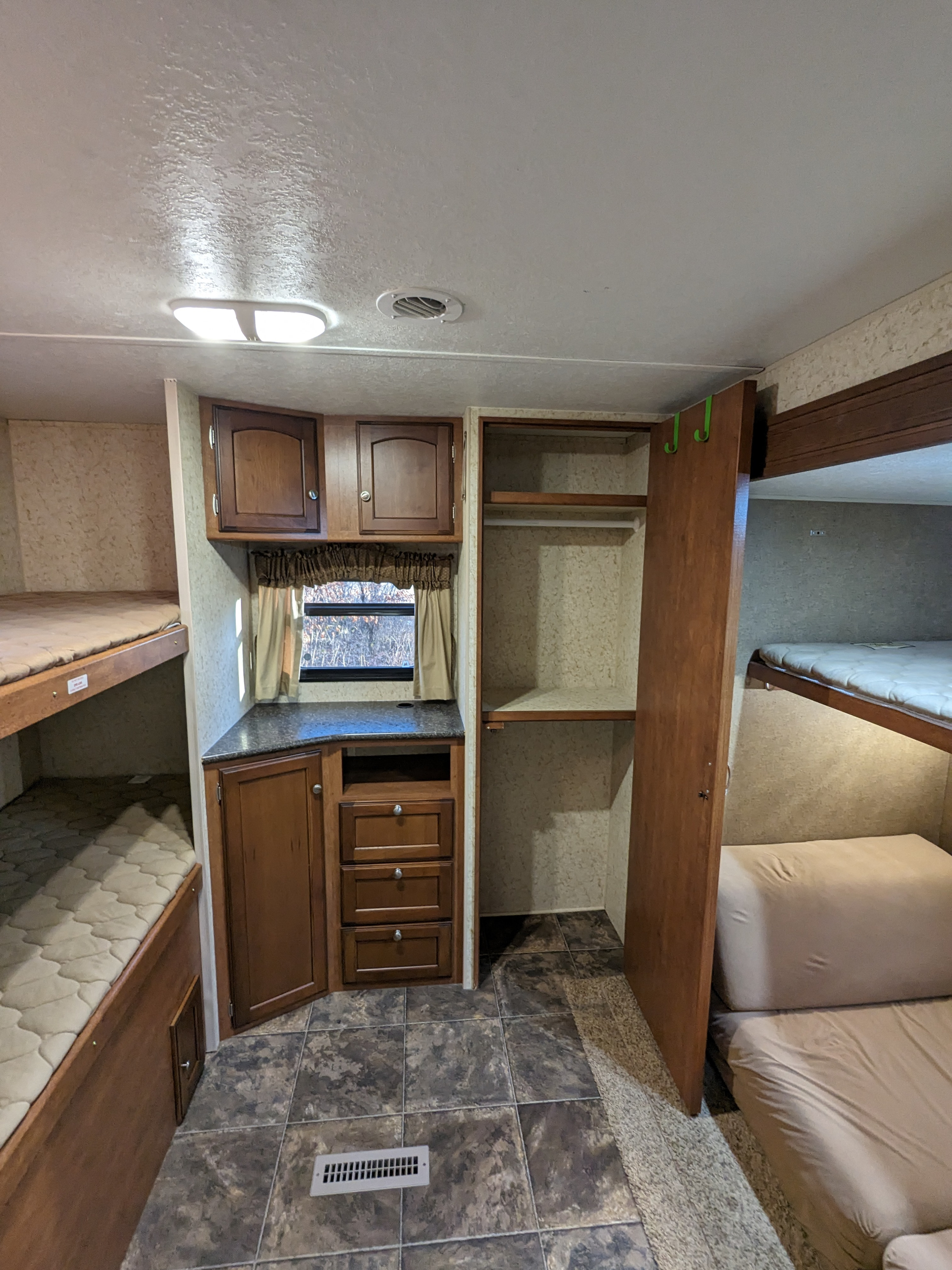 Spacious RV rental interior with comfortable bunk beds, ample storage cabinets, and a convenient wardrobe.. Winnebago Sunset Creek 2014