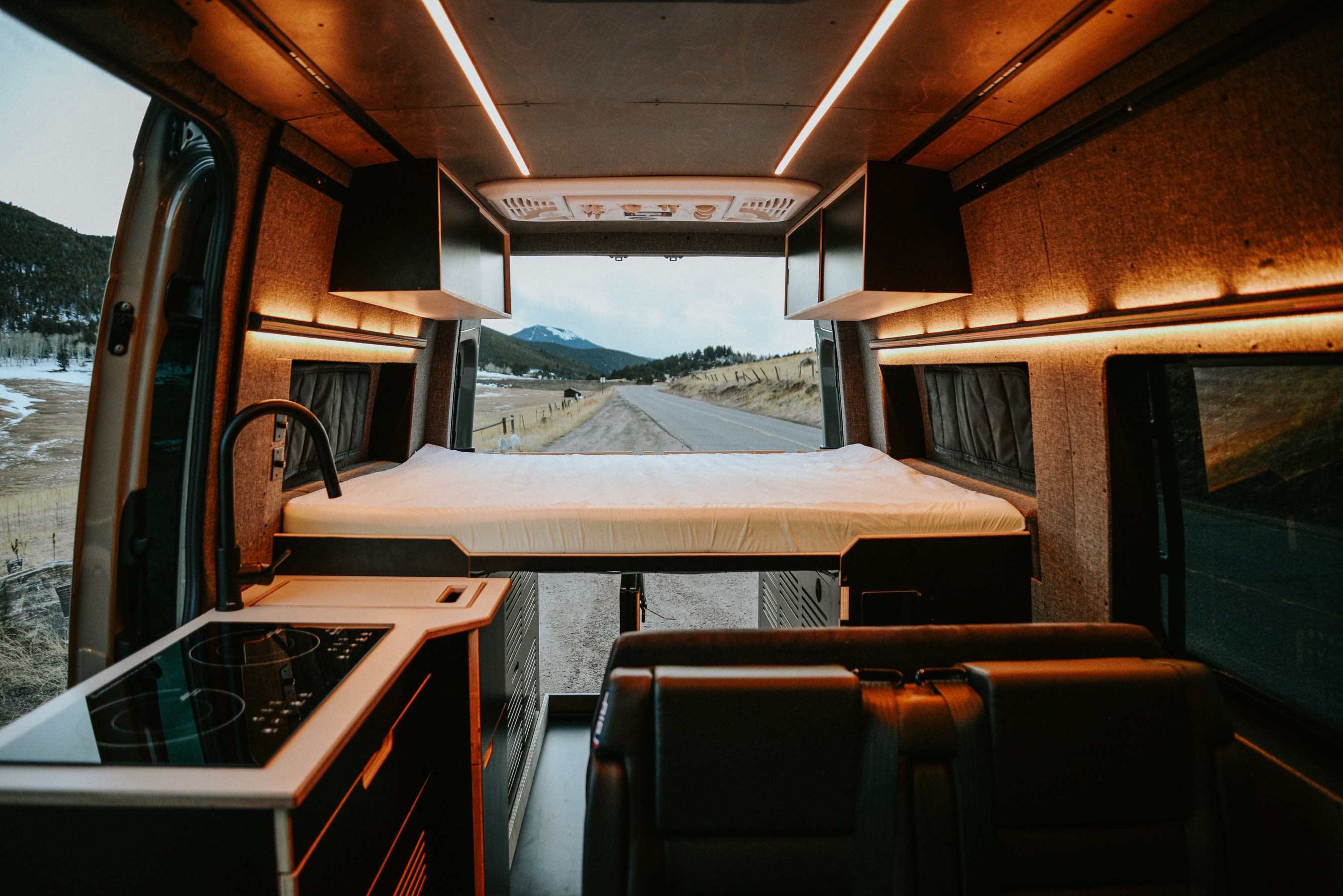 Spacious RV rental camper van with kitchen, elevated bed, & scenic mountain view from inside.. Mercedes Sprinter 2021