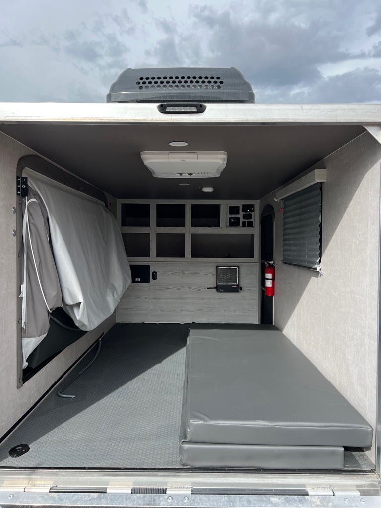 RV rental: View inside a functional camper/toy hauler, showing a fold-out bed, workstation, and durable floor.. Eclipse Recreational Vehicles Mojo-12 BD 2024