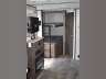 View inside a modern RV rental, showing the living area with a counter and a hallway leading to the back. Ideal for travel adventures.. Dutchmen Coleman Light 2020