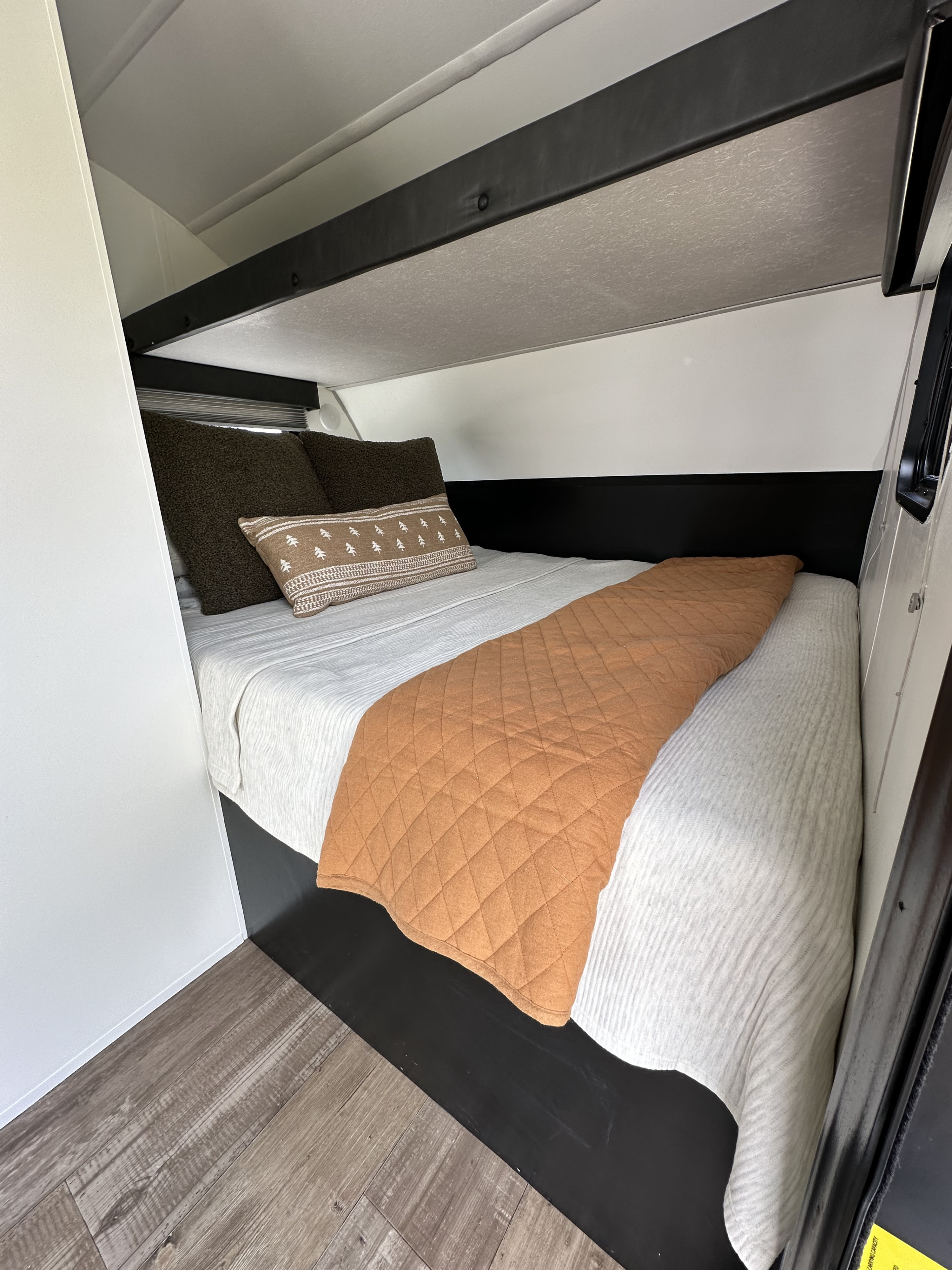 Relaxing RV rental bunk bed setup with cozy pillows, a soft sheet, and a warm blanket. Perfect for a restful night.. Forest River Cherokee Wolf Pup 2021