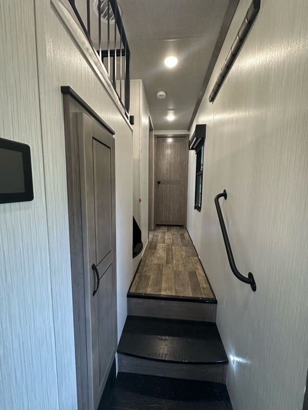 Bright RV rental hallway with stairs leading to wood-look flooring, plus a loft railing.. Forest River Other 2021