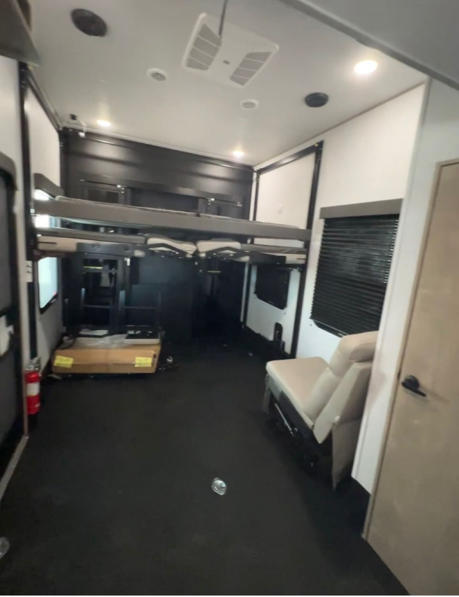 Versatile RV rental toy hauler interior, showcasing retractable bunk beds, ample garage space, and seating.. Grand Design Momentum M-Class Toy Hauler 2023