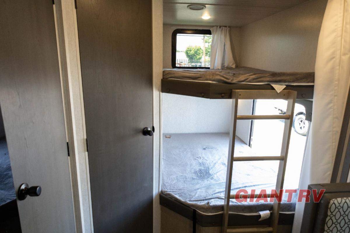 Inside a spacious RV rental, a bunk bed setup with a ladder and window offers comfortable sleeping for your camping adventures.. Forest River Evo CSJT2650G 2023