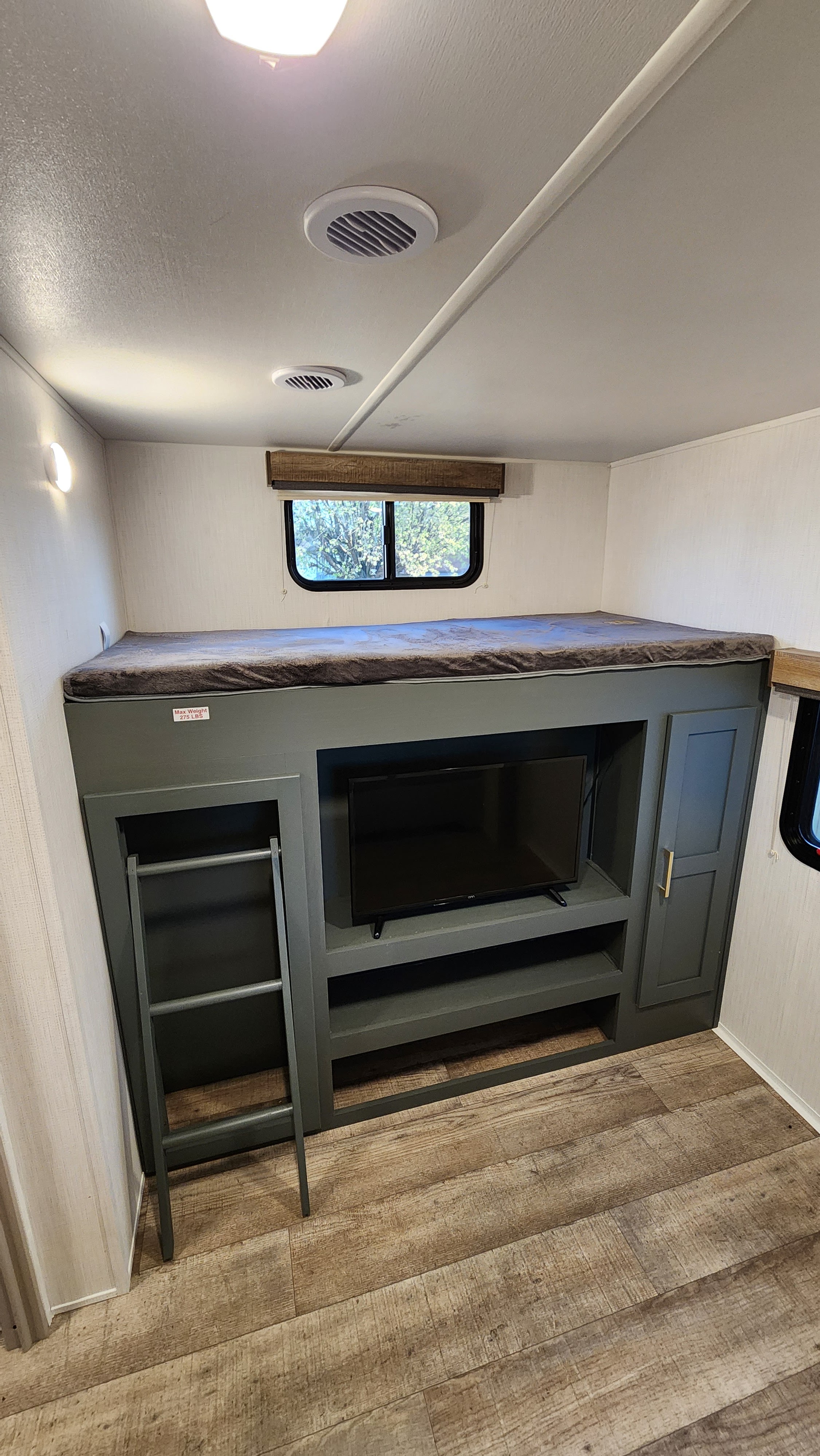 RV rental: Interior bunkhouse with cozy bed, ladder, built-in TV, and storage. Max weight 275 lbs.. Heartland RVs Eddie Bauer 2024