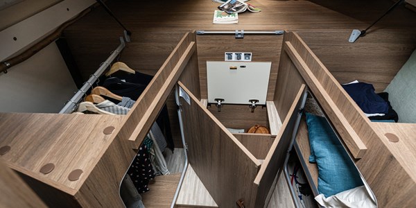 Optimized RV rental interior with organized storage: clothes rail, shelves, and central access panel.. Elnagh Baron 573 2024